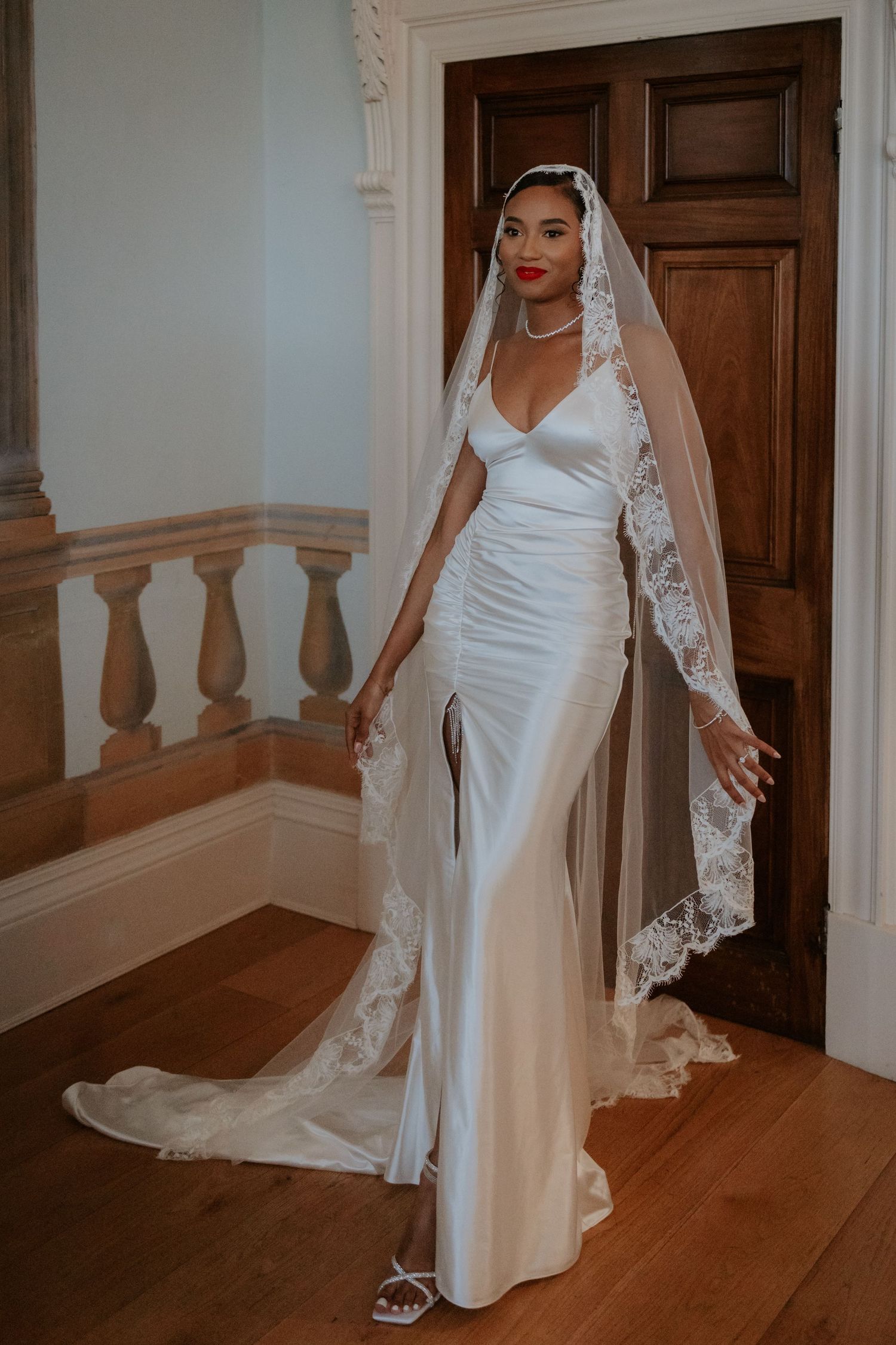 Elegant white satin wedding gown with delicate lace veil and train.