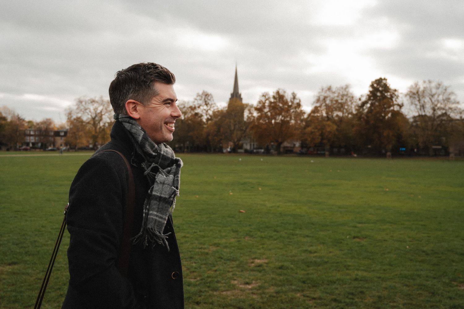 founder man walking in park with coat and scarf