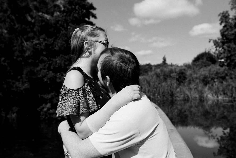 Black and white portrait of couple sharing tender moment outdoors.