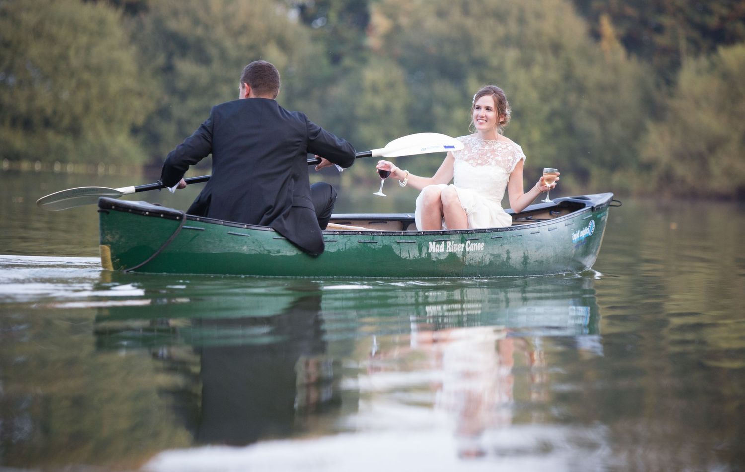 Bride and groom in kayak at Sopley lake, Dorset on their wedding day