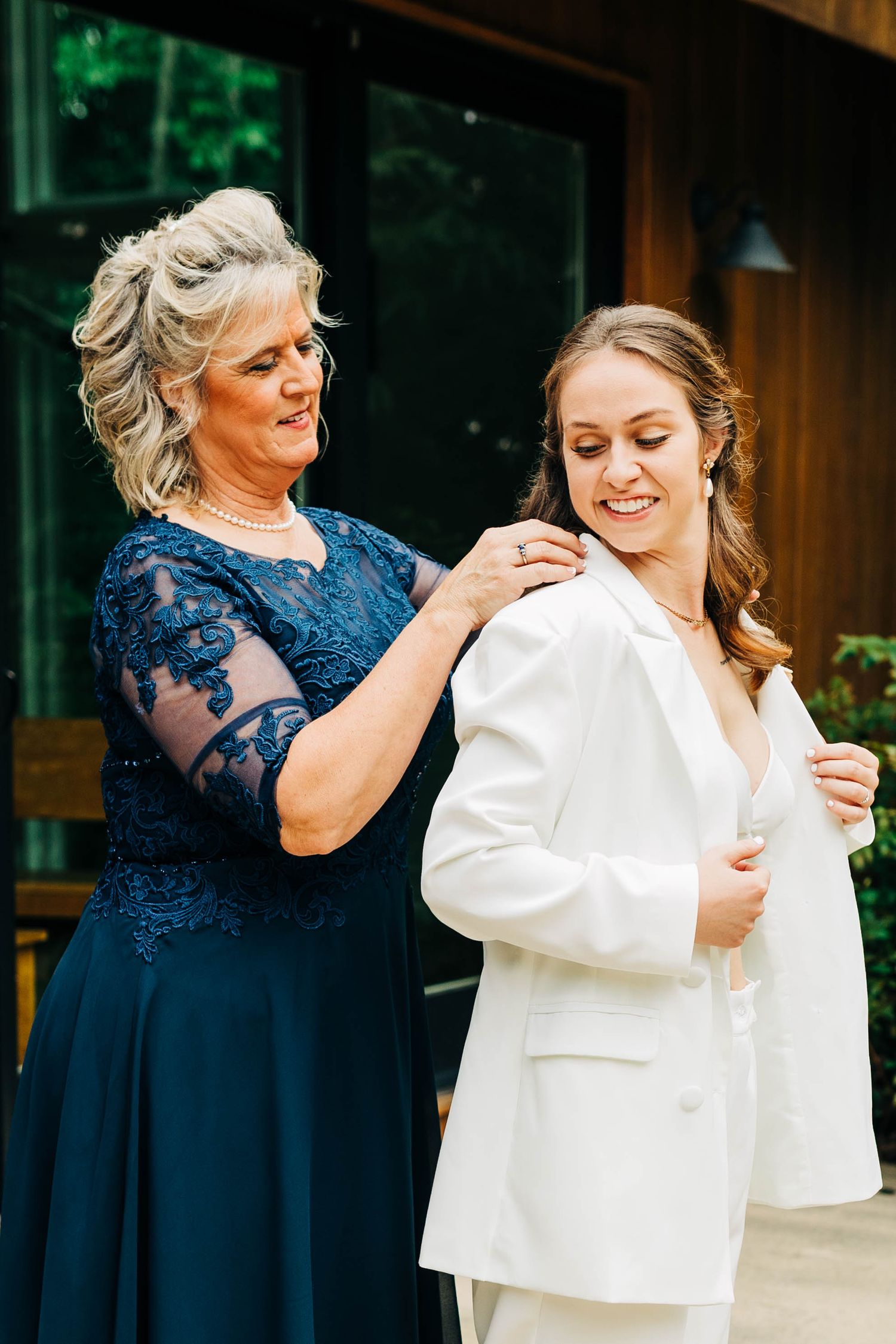Getting ready moment in a white suit with navy blue lace dress details.