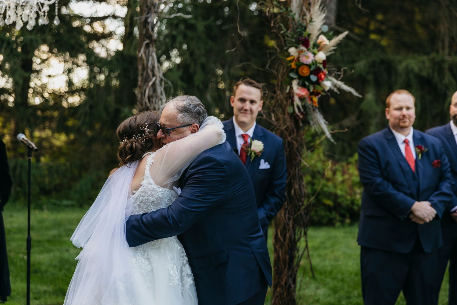 Wedding celebration in a garden setting with autumn trees in the background.