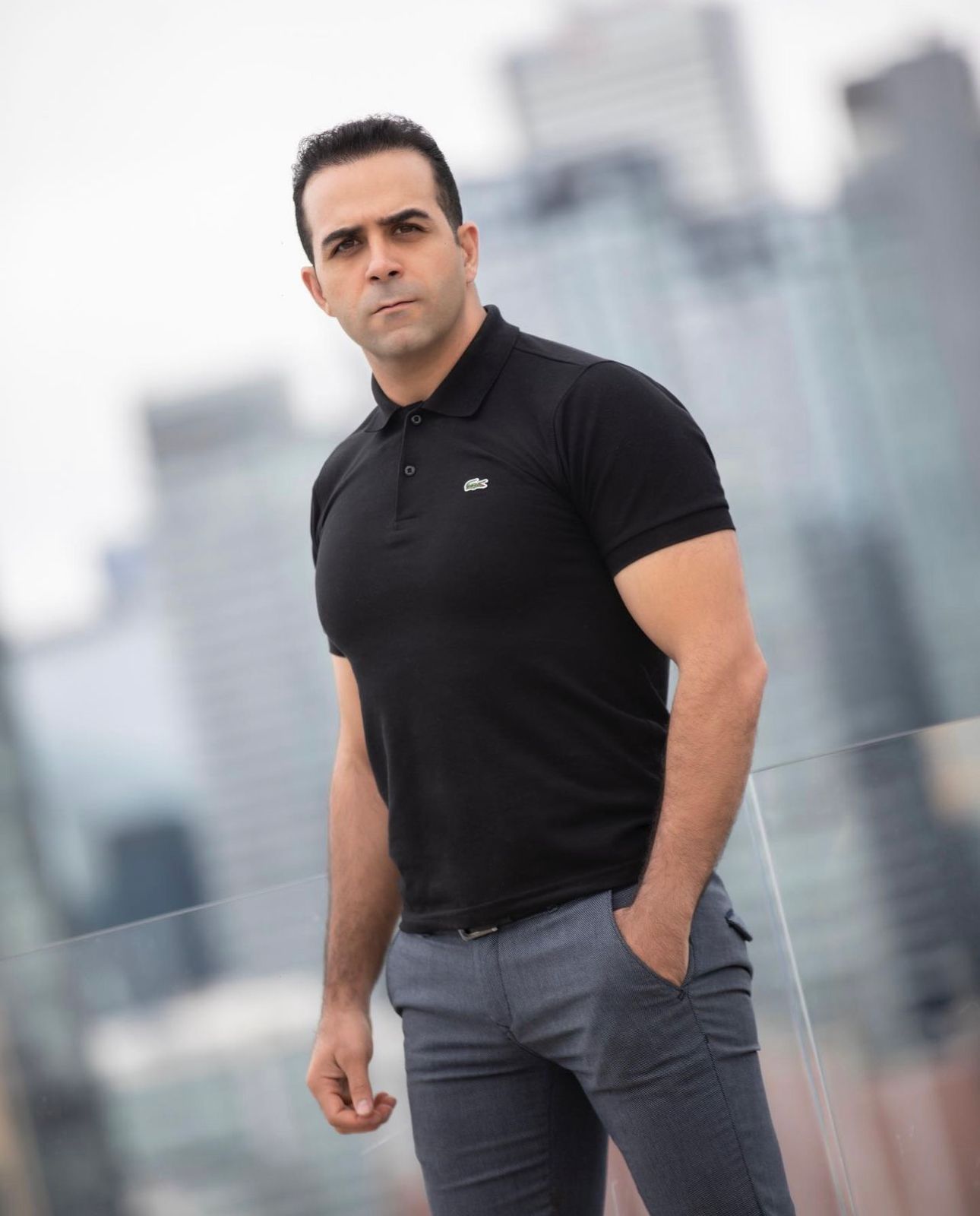 Urban lifestyle portrait with city skyline backdrop and modern casual attire.