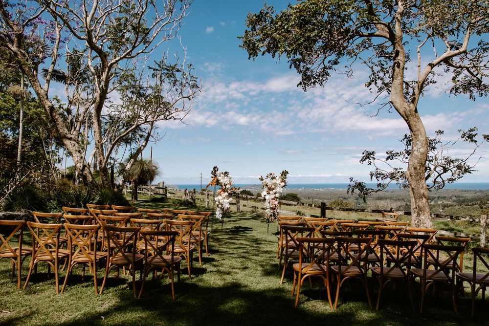 Garden wedding ceremony setup with cross-back chairs arranged in rows overlooking valley views.