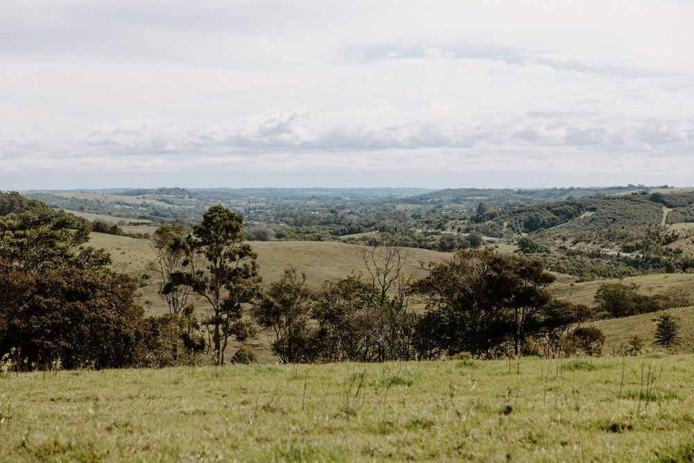 Rolling hills and pastoral countryside landscape stretching to the horizon under cloudy skies.