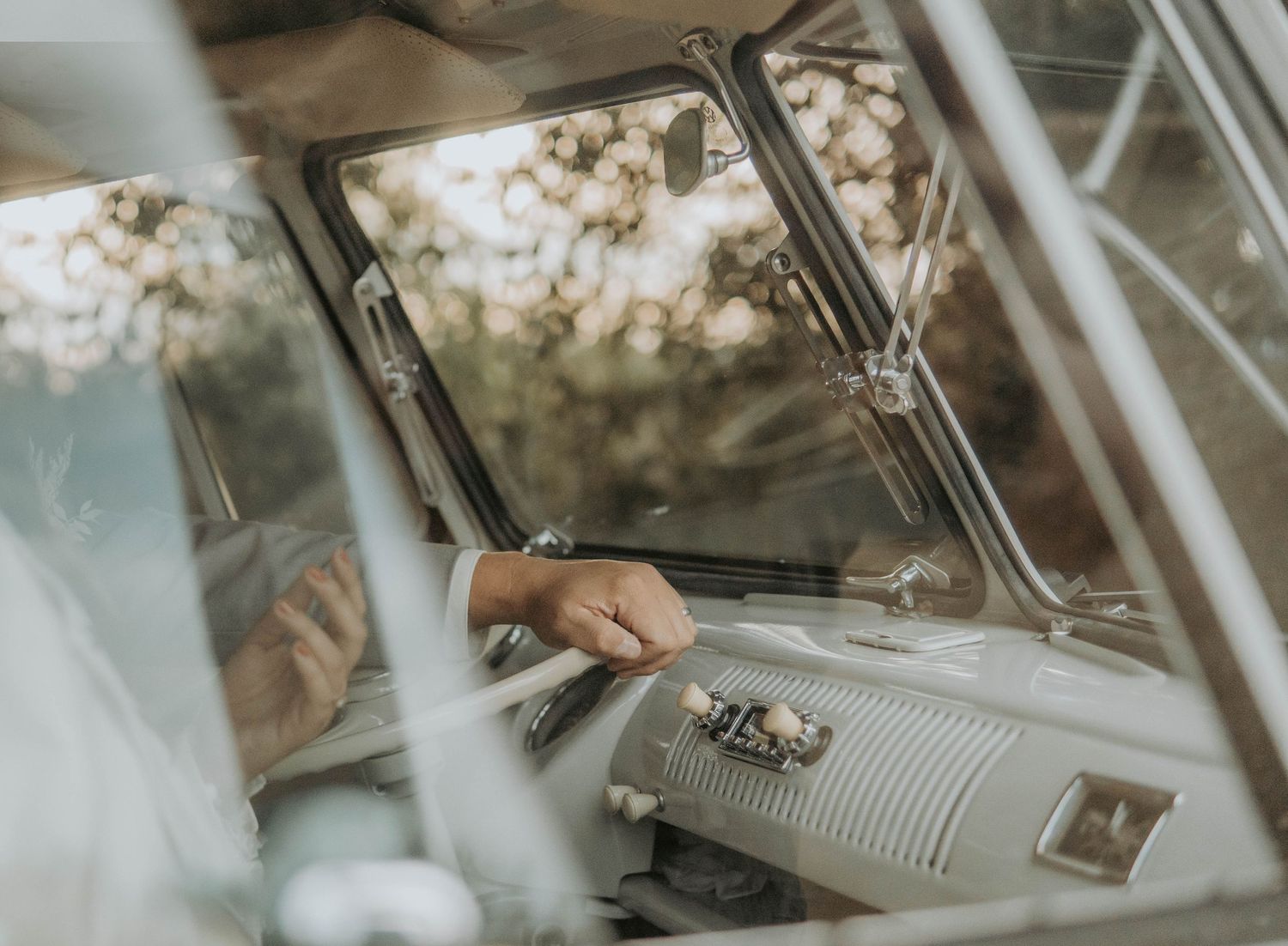Interior view of a classic car dashboard and steering wheel with natural lighting.
