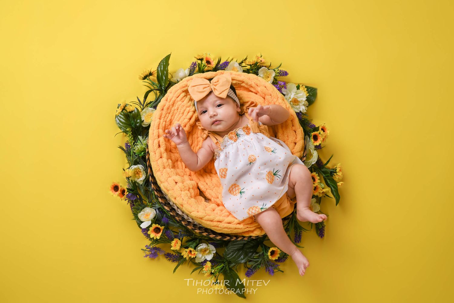 Бебешка фотосесия жълт фон с кръг от жълти и зелени цветя