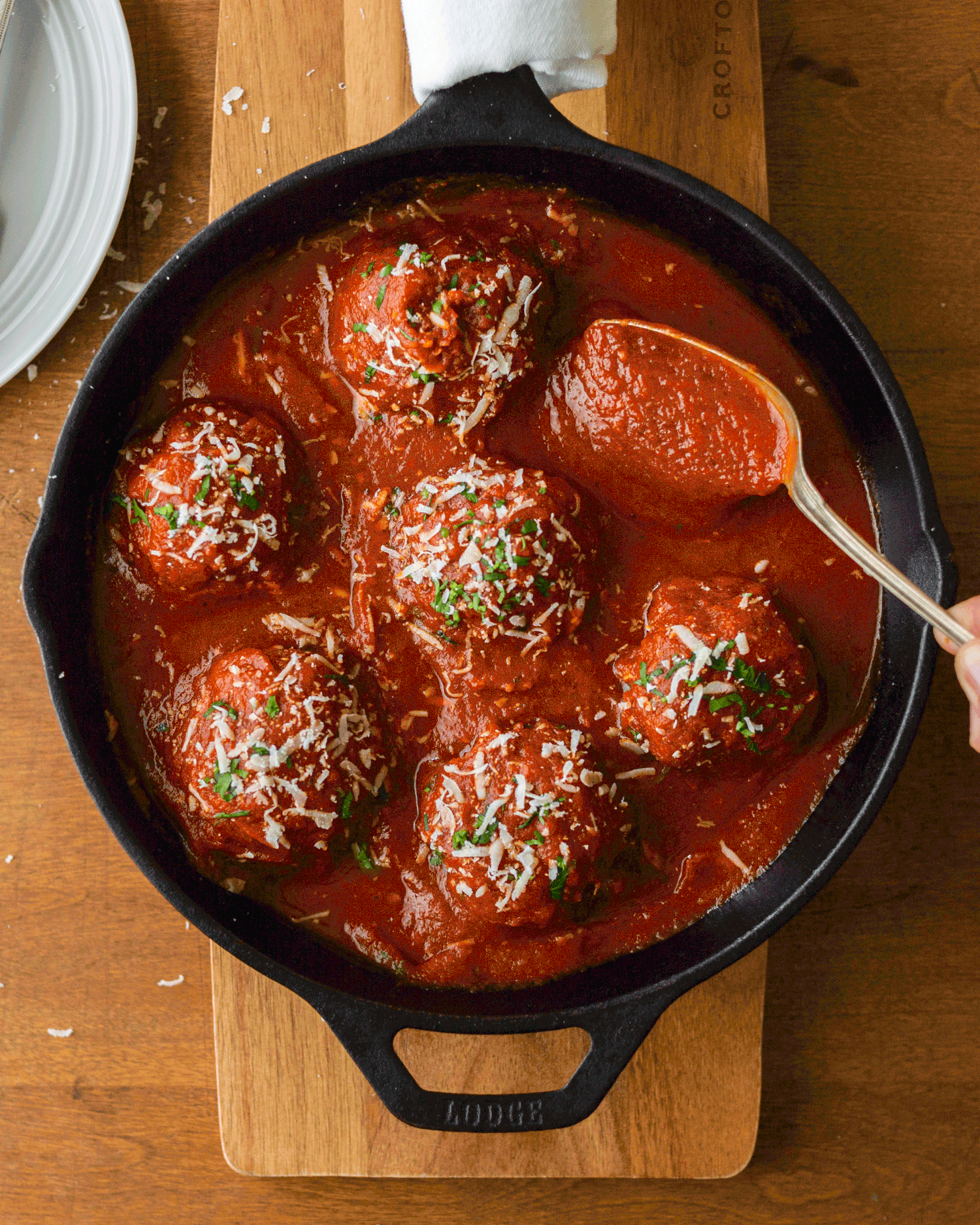 meatballs-with-sauce-pour-on-skillet-wooden-board
