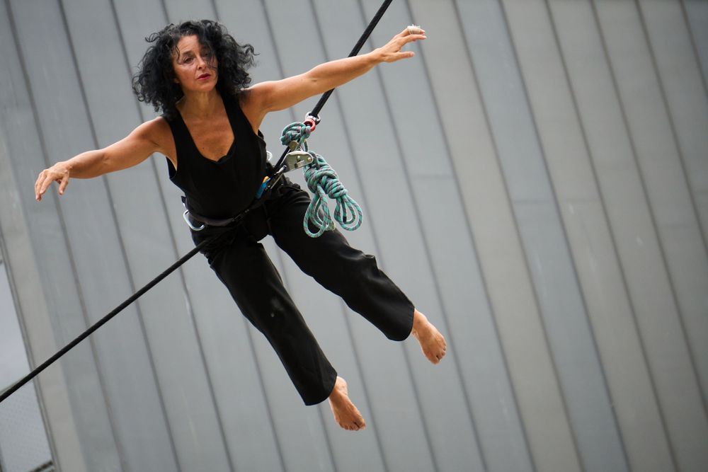 A dancer gracefully suspended in mid-air performing an aerial dance move.