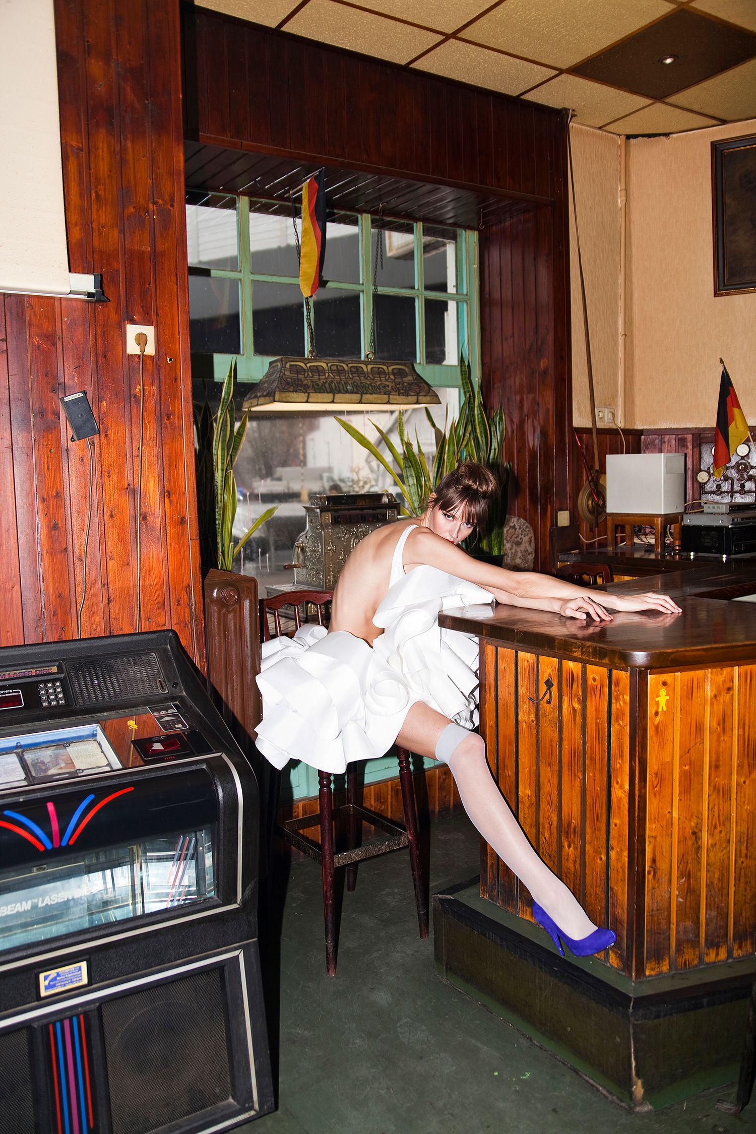 Series of images showing someone interacting with an arcade machine in a wood-paneled room.