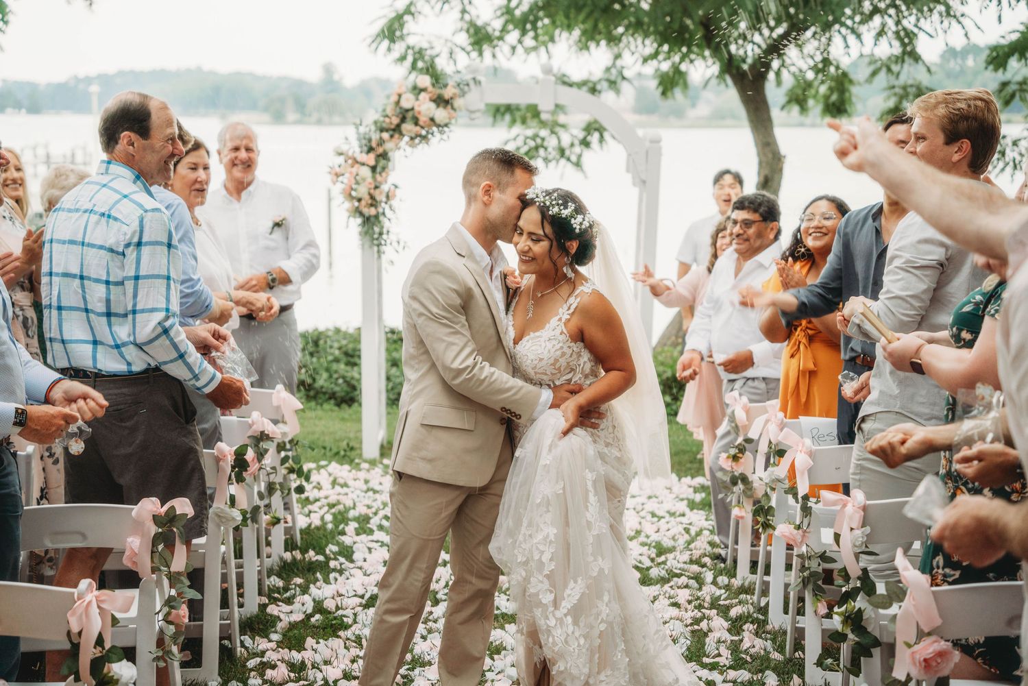 Outdoor wedding reception with guests celebrating under string lights.