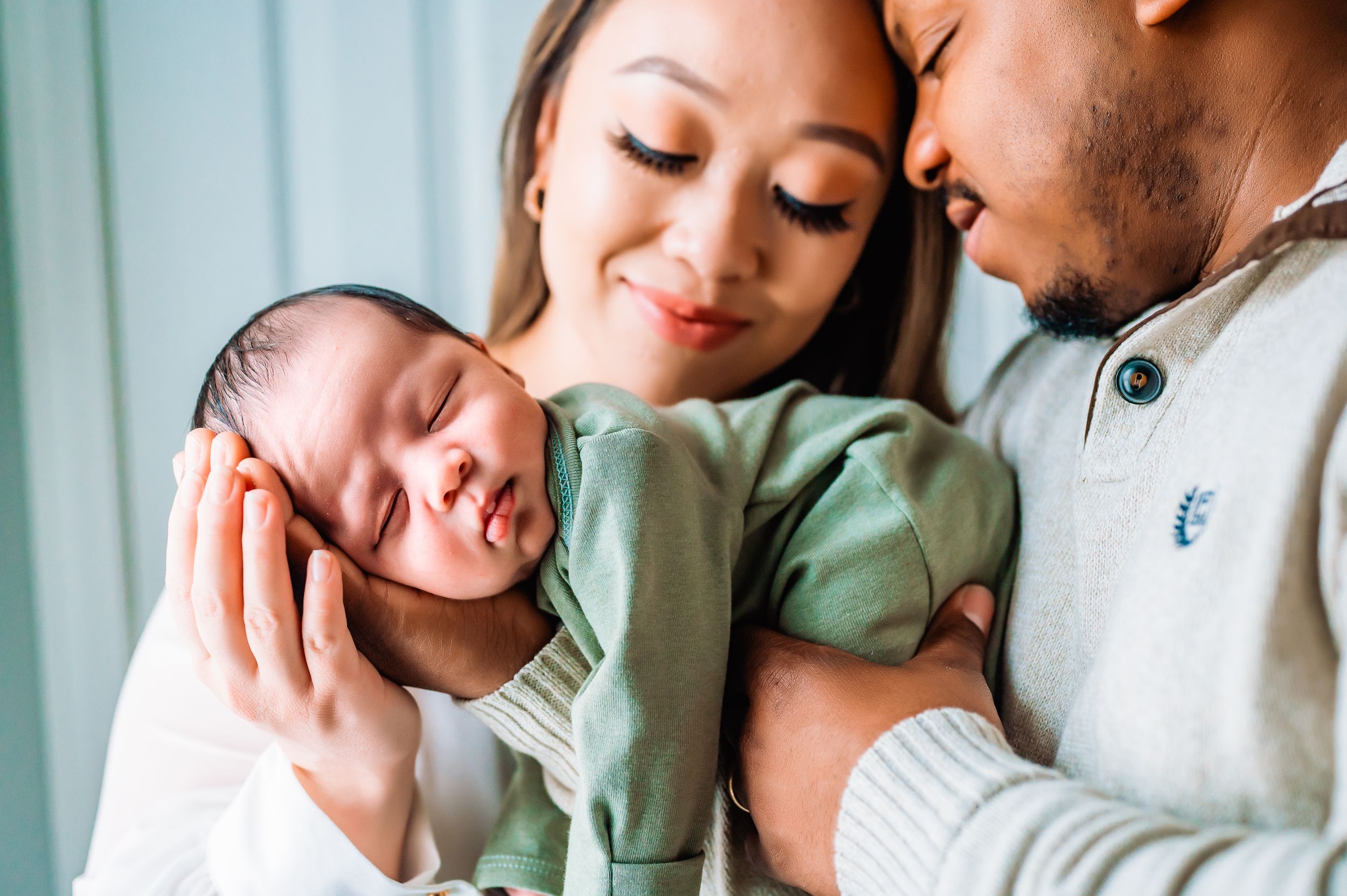 Staten Island couple holding newborn baby in green gown