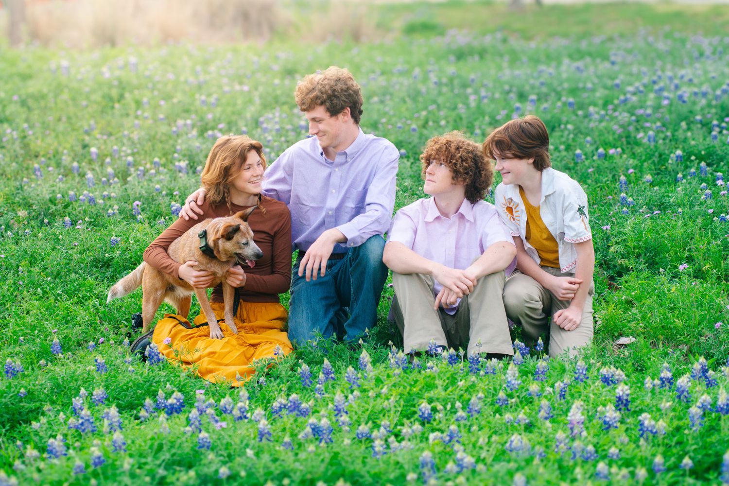 Family sitting together among bluebonnets in the Texas Hill Country