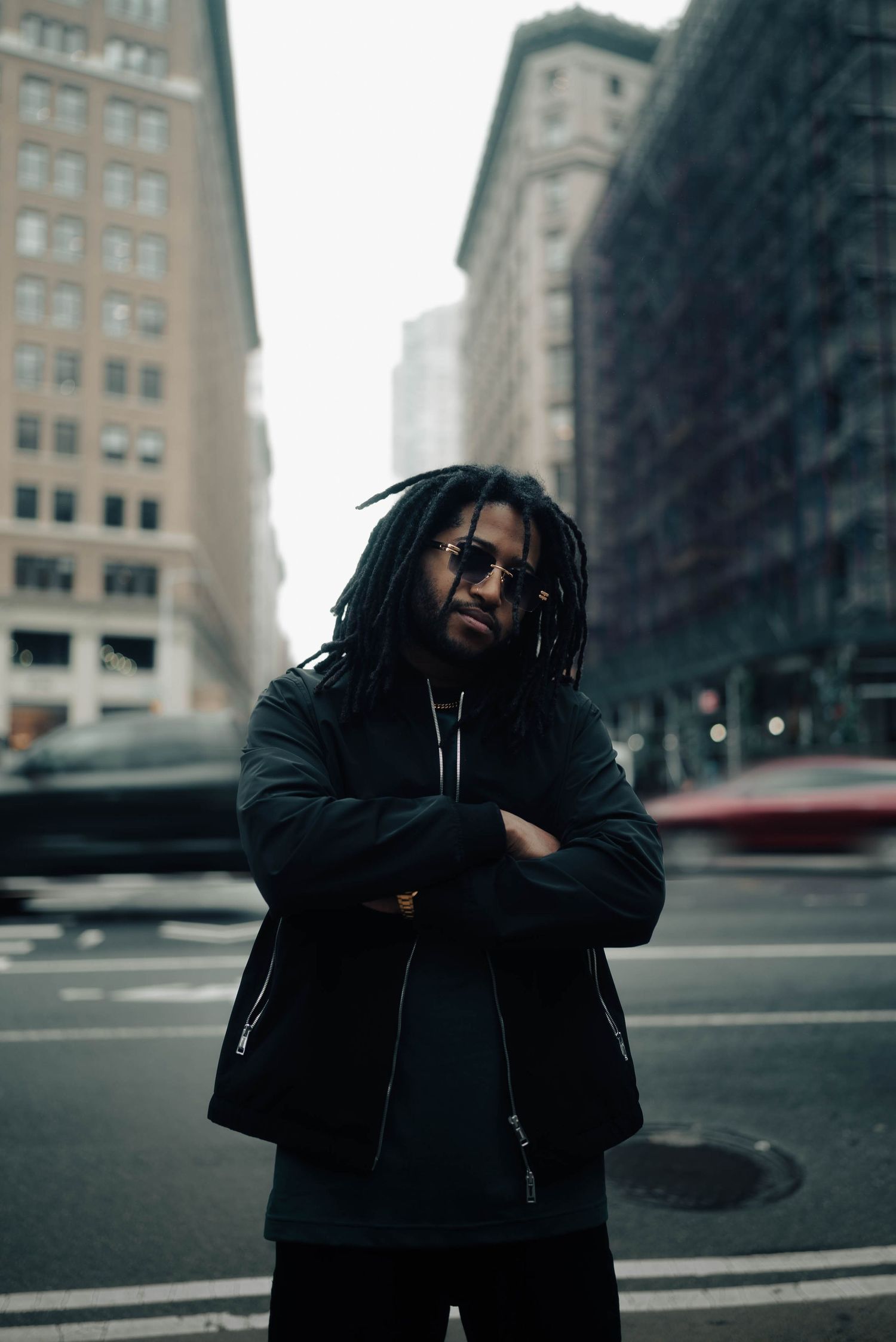 Urban street photography series showing a person in dark winter clothing against city buildings on an overcast day.