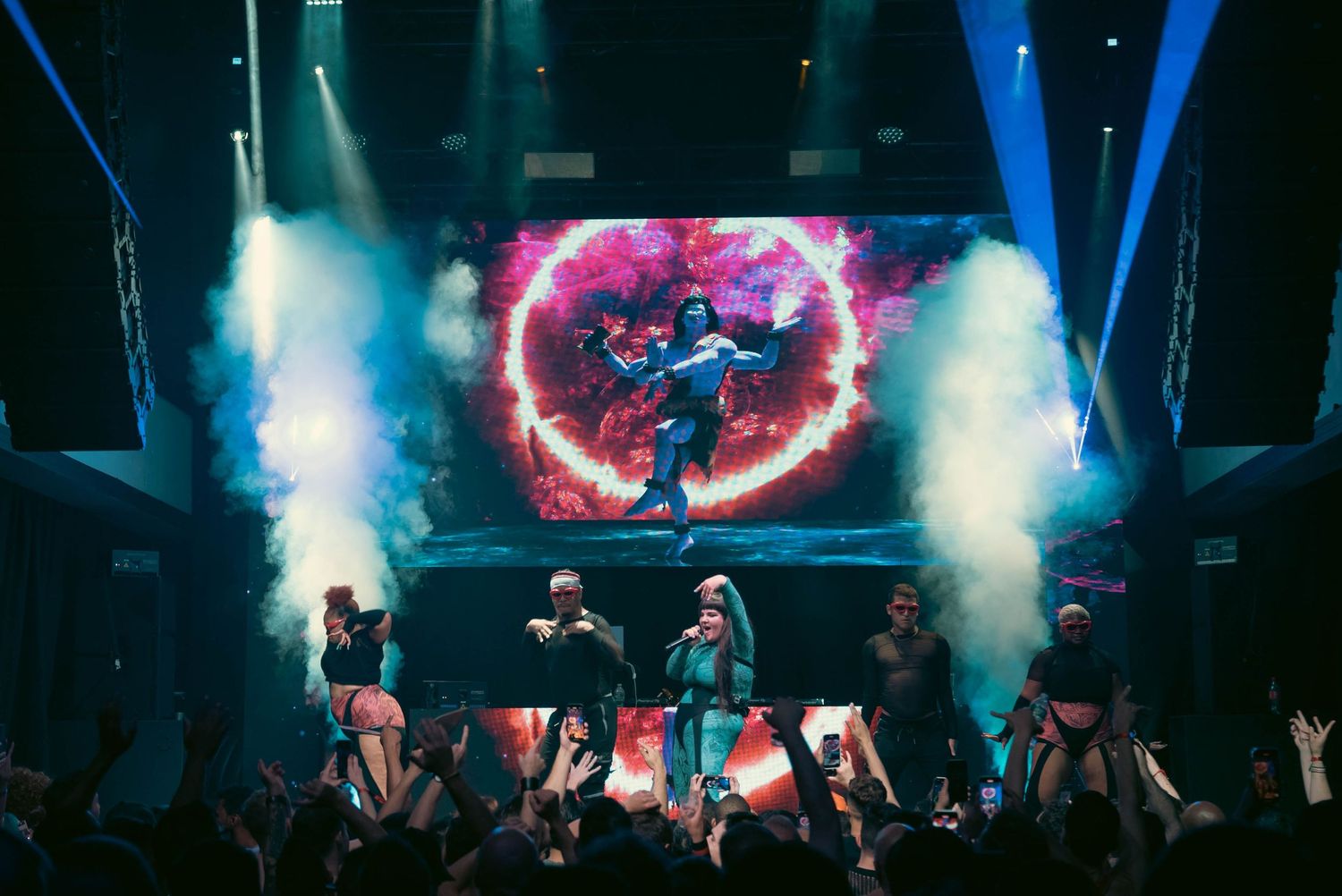 Concert stage illuminated with blue and red lights creating an atmospheric performance environment.