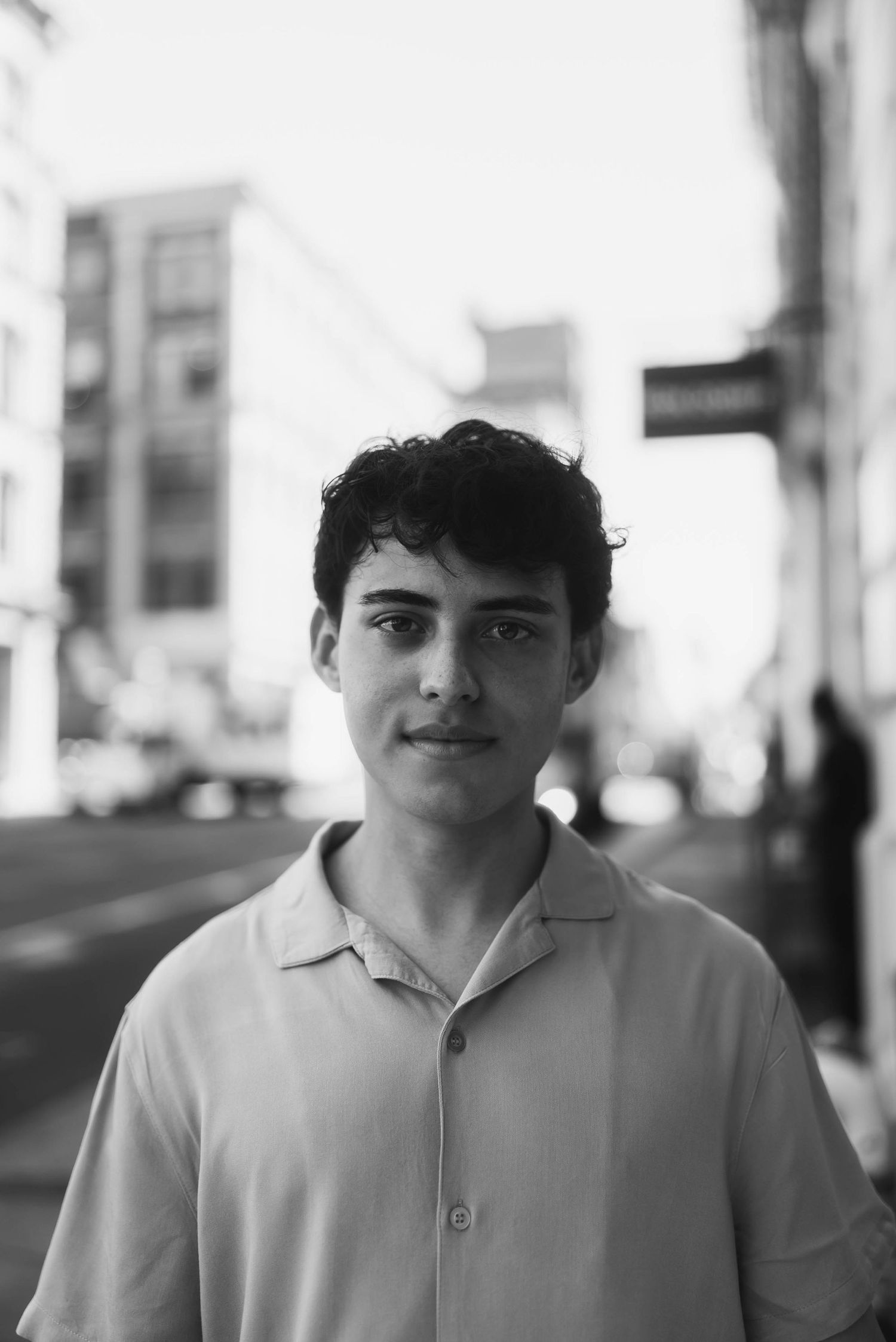 Black and white street portrait with urban background.