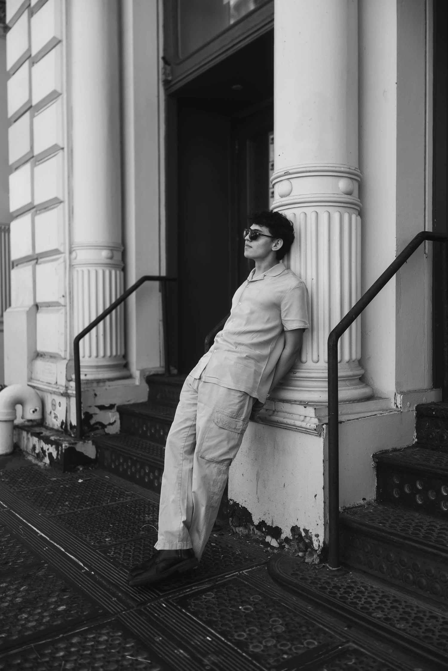 Black and white architectural portrait featuring classical columns and iron railings.