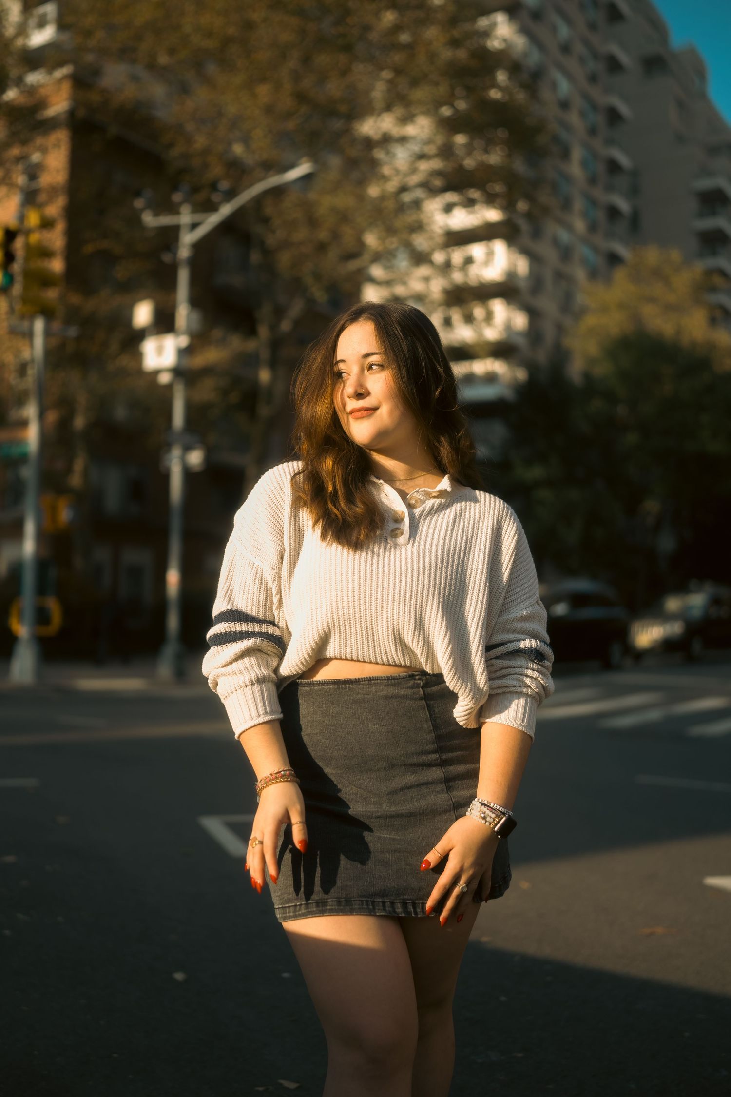 Urban photoshoot at sunset featuring casual knitwear styling.