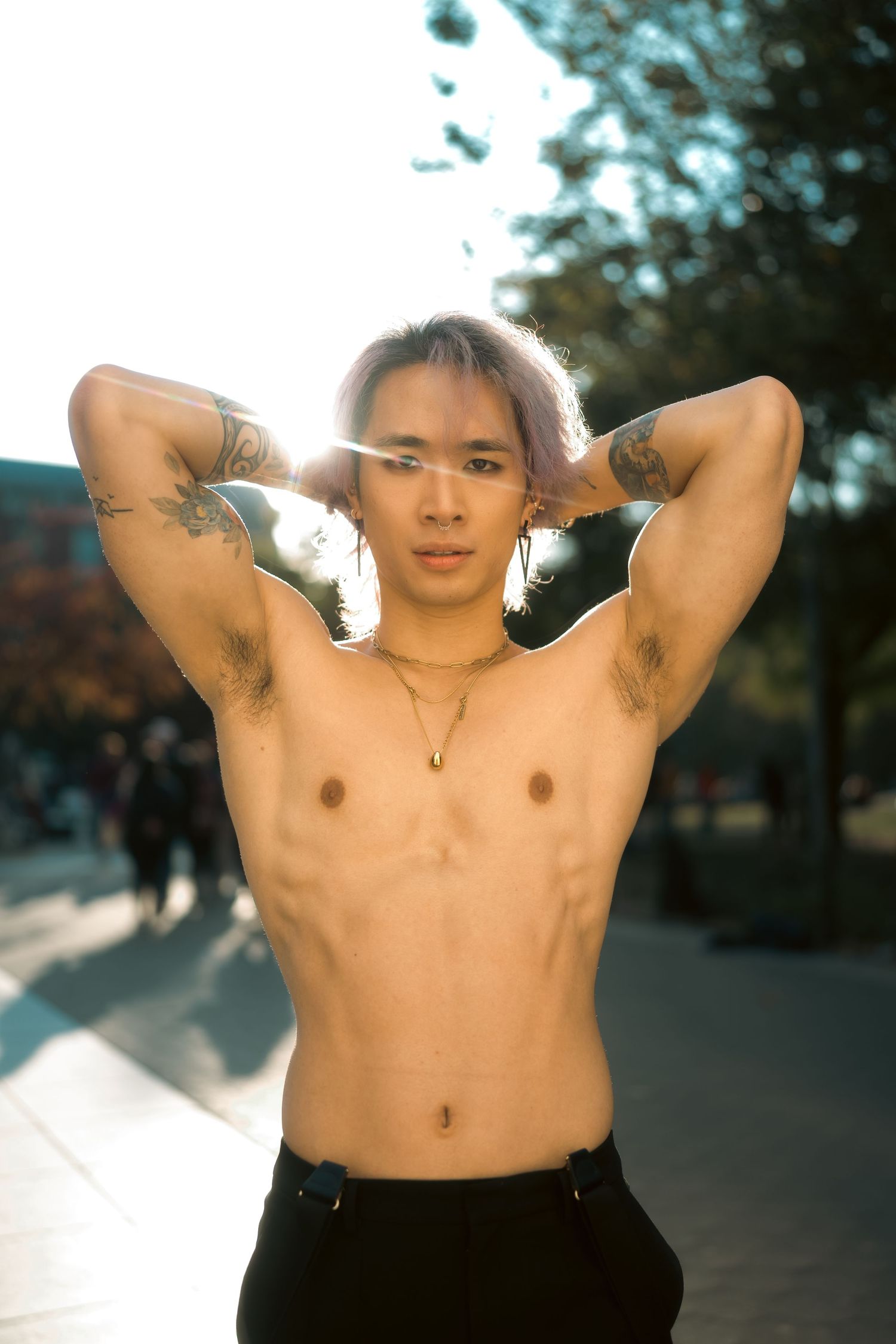 Outdoor portrait with natural backlighting and urban scenery.