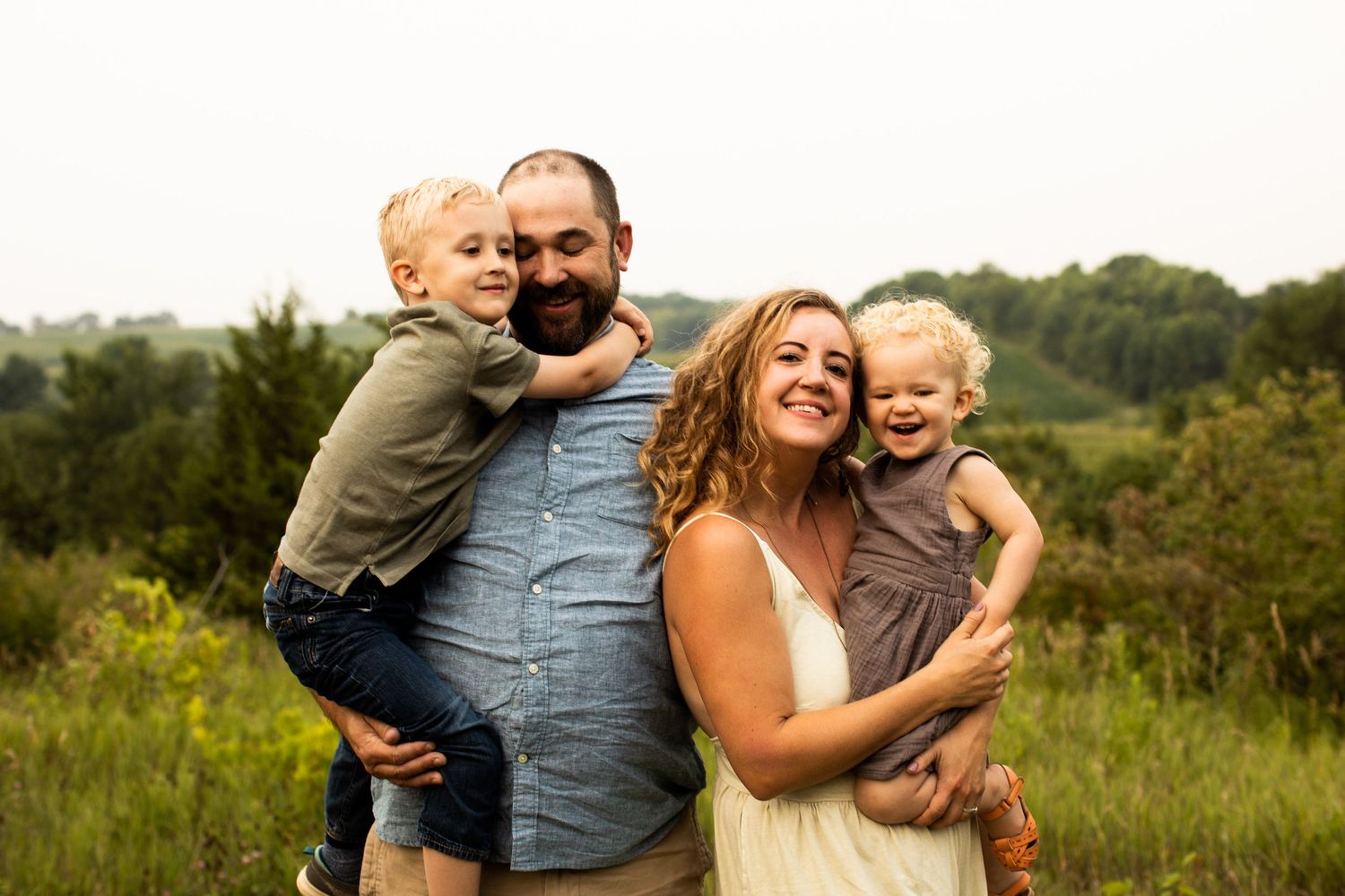 Lifestyle portrait of Miranda's family snuggling and laughing on their farm