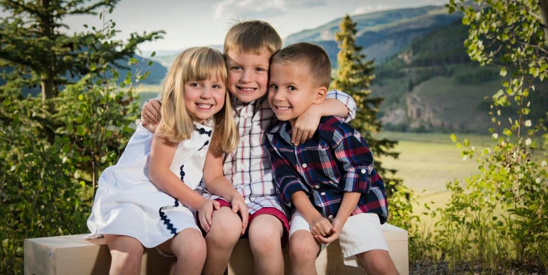 Three little siblings with mountain view background