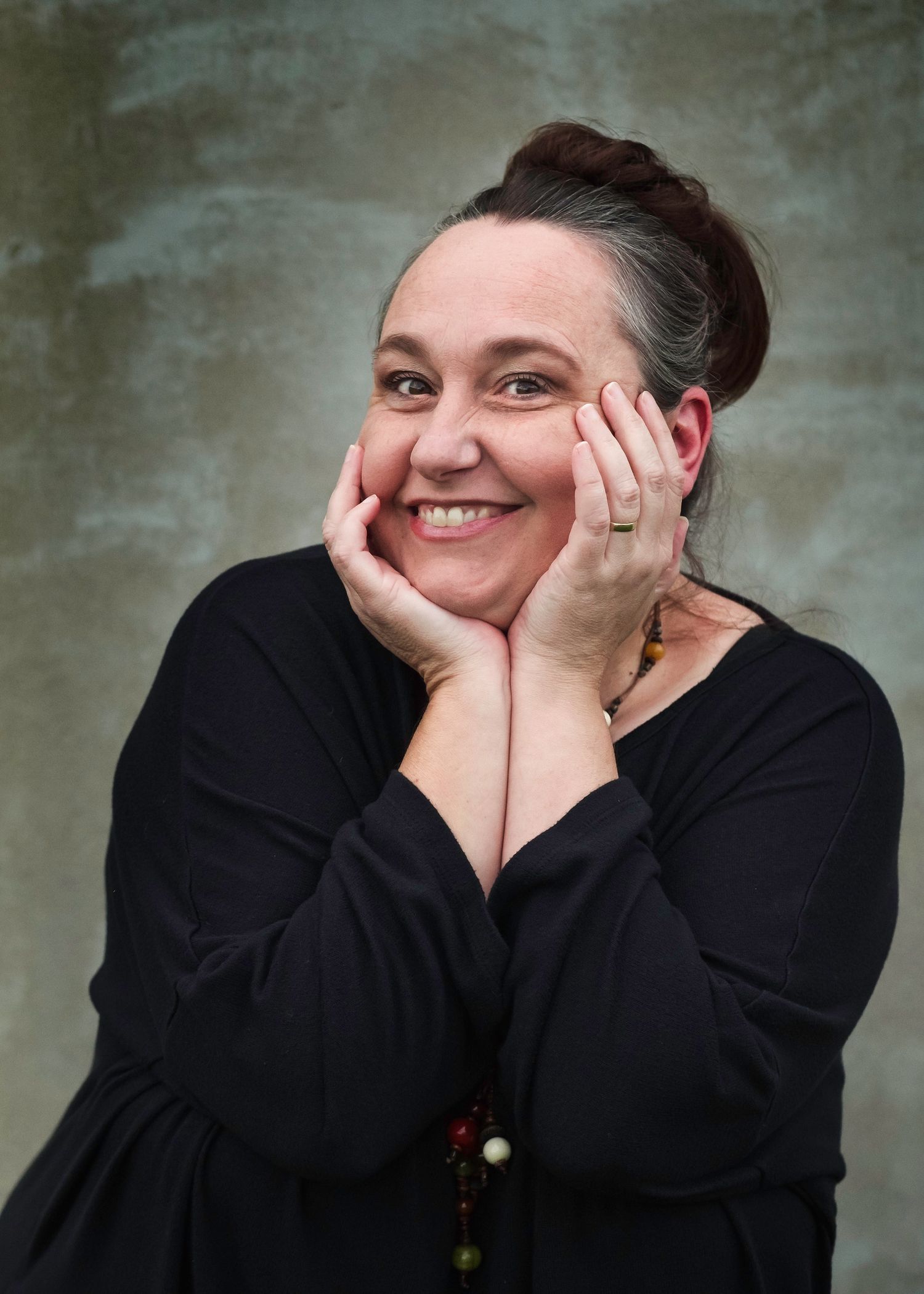 Joyful expressions captured in black clothing against a textured grey background.