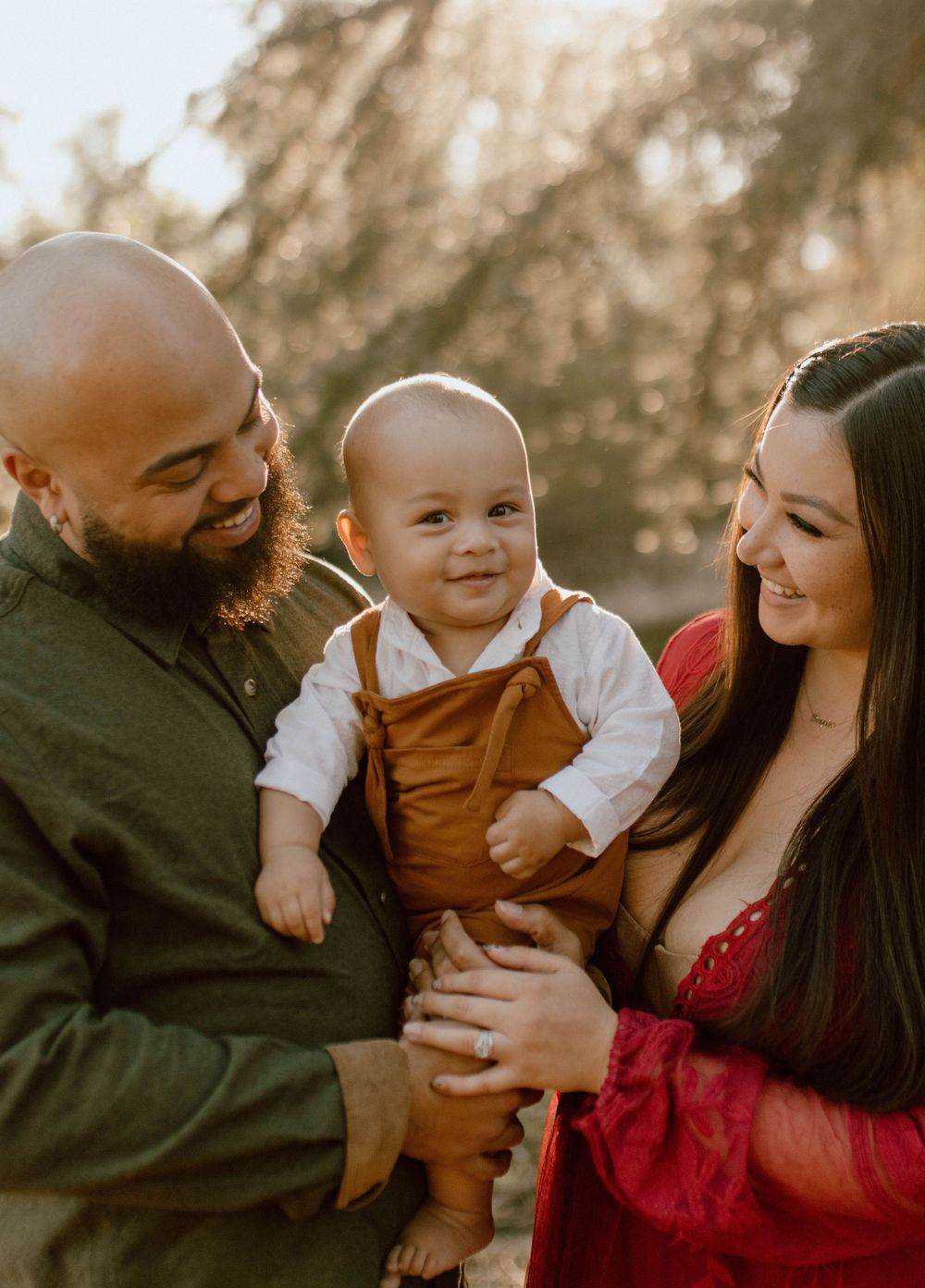 Family sharing a warm moment together outdoors during golden hour sunset in casual autumn attire.