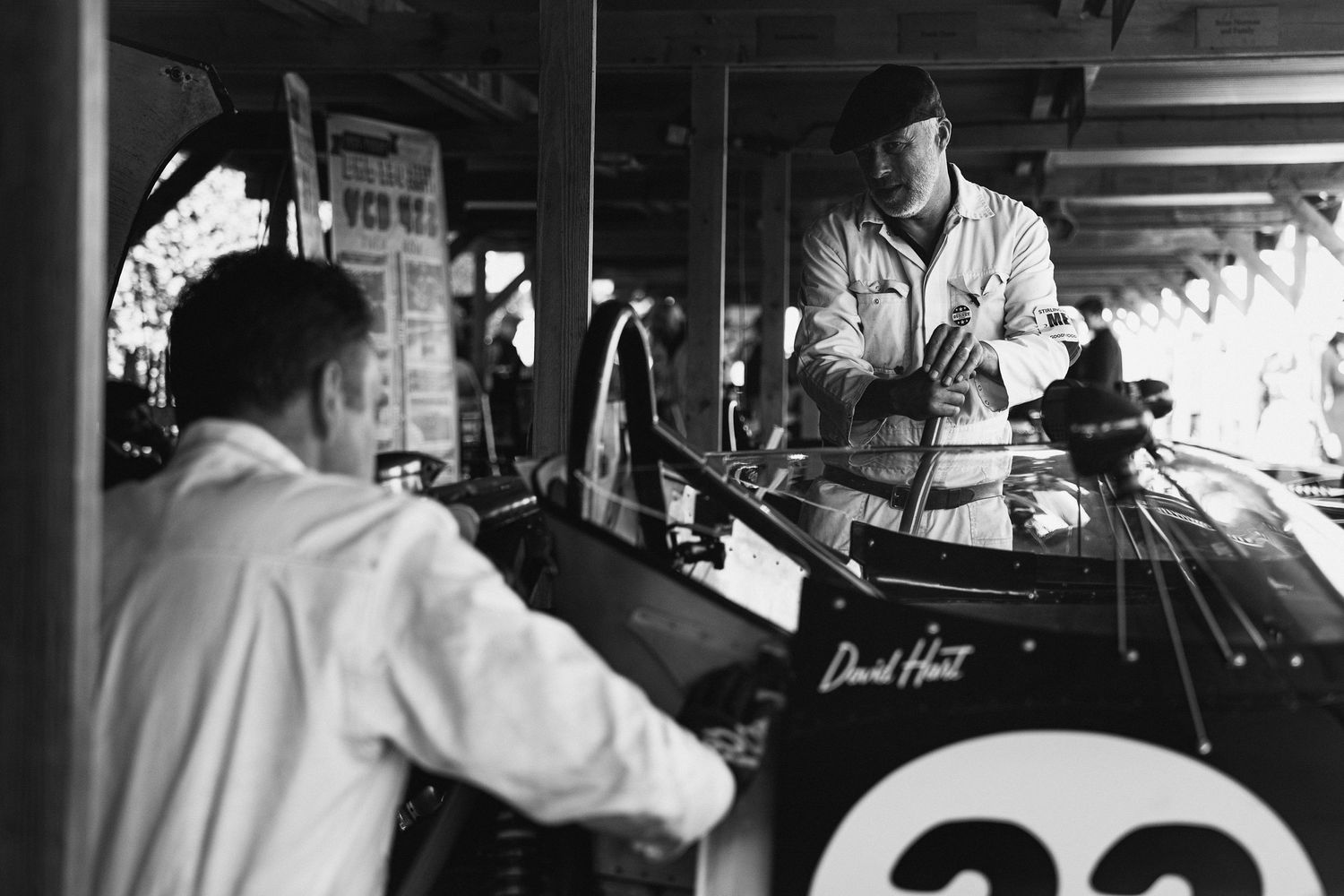 Interior view of classic car dashboard gauges and controls in black and white.