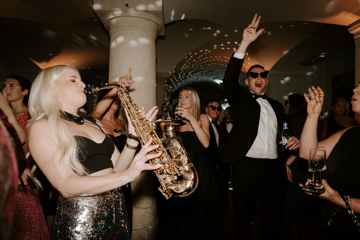 saxophonist playing to dancing guests on the dance floor in the vaults at the ashmolean museum in Oxford