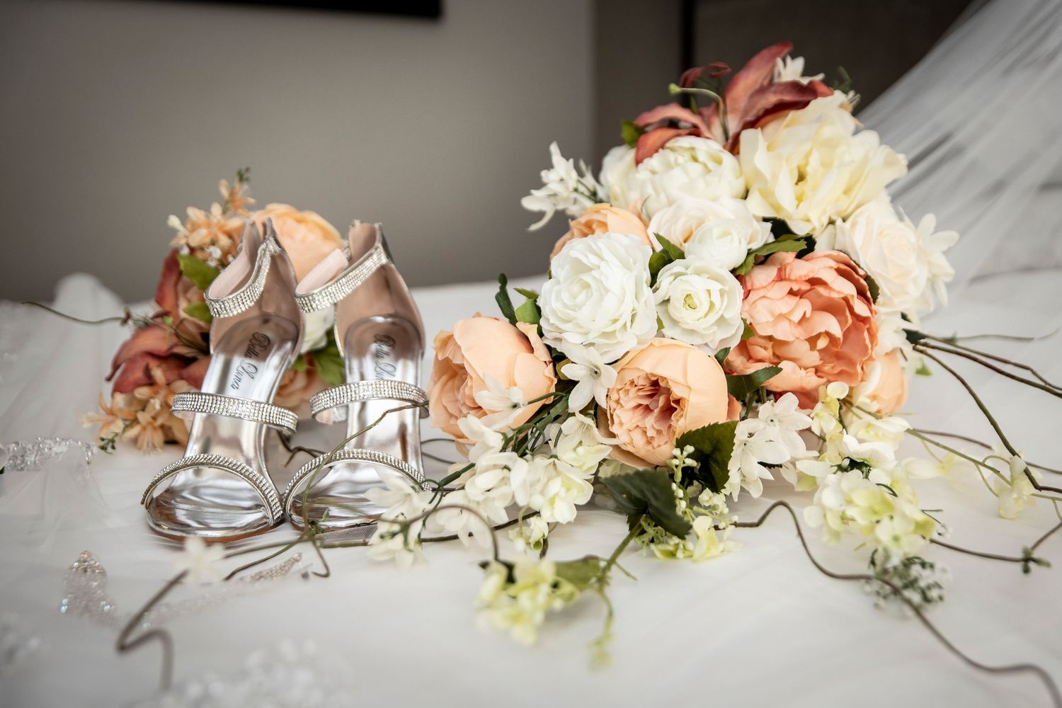 Romantic bridal bouquet featuring blush pink and white roses with cascading greenery on a white tablecloth.
