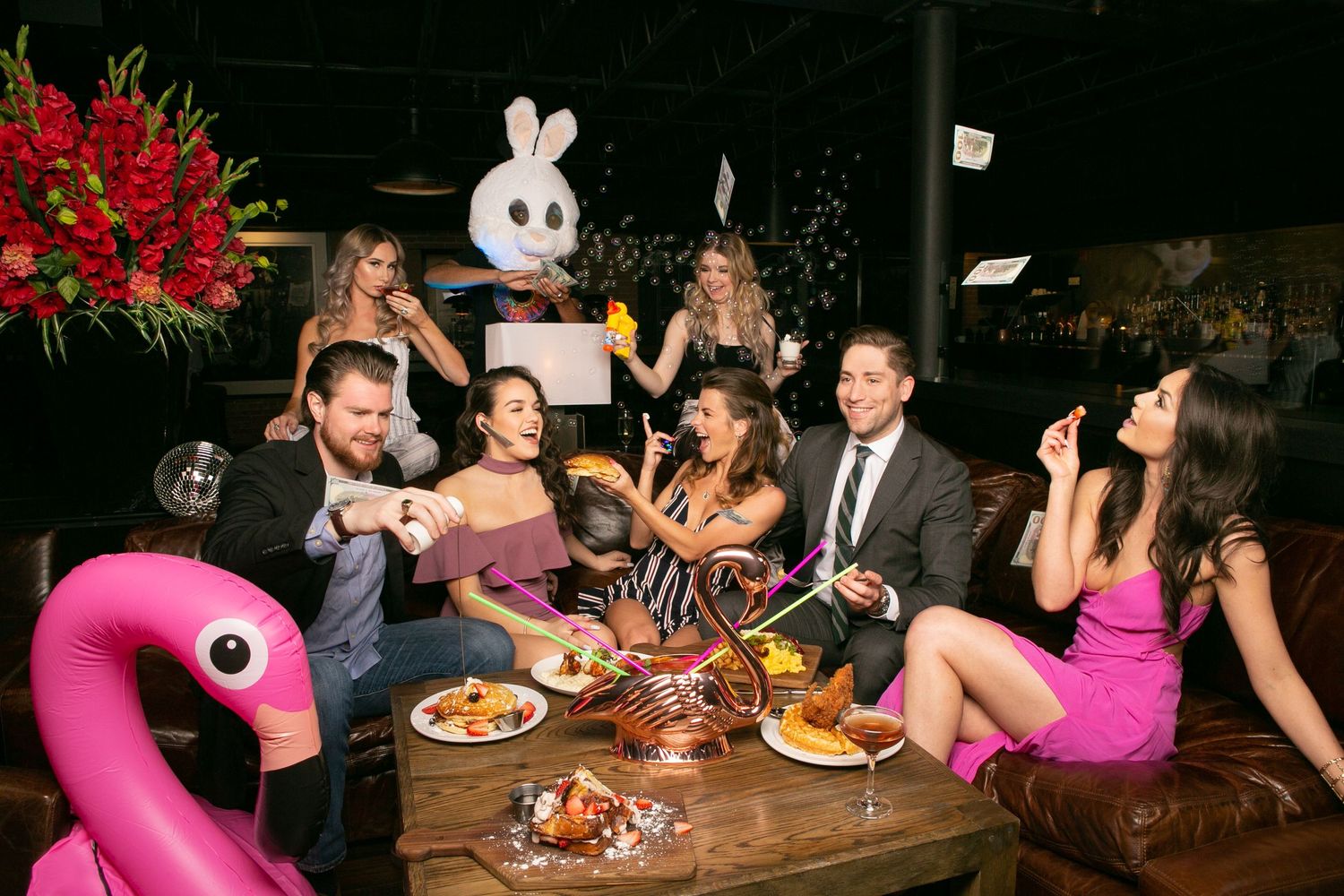 Group enjoying cocktails and appetizers at an upscale restaurant bar.