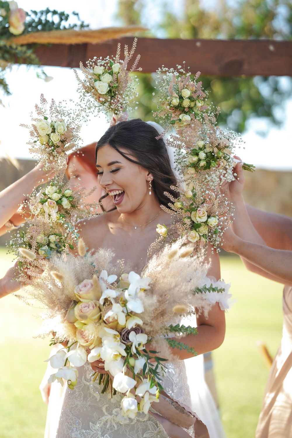 Beautiful wedding bouquets with delicate white flowers and pampas grass in natural sunlight.