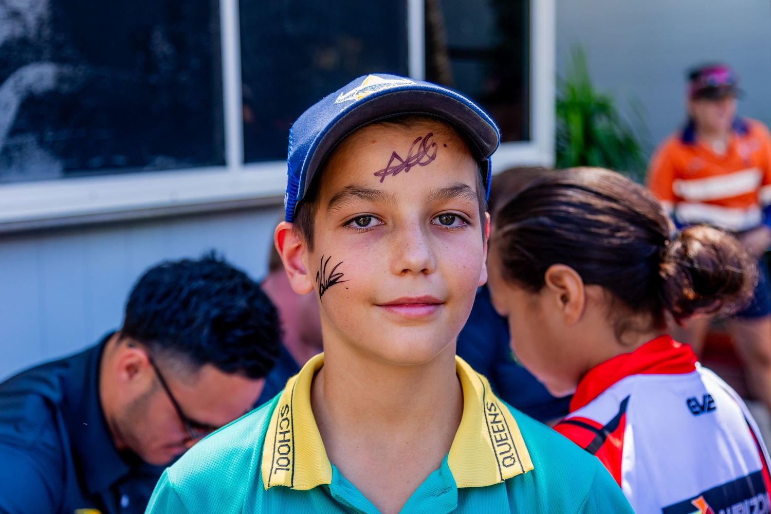 Young sports fan in Australian team colors at an outdoor event.
