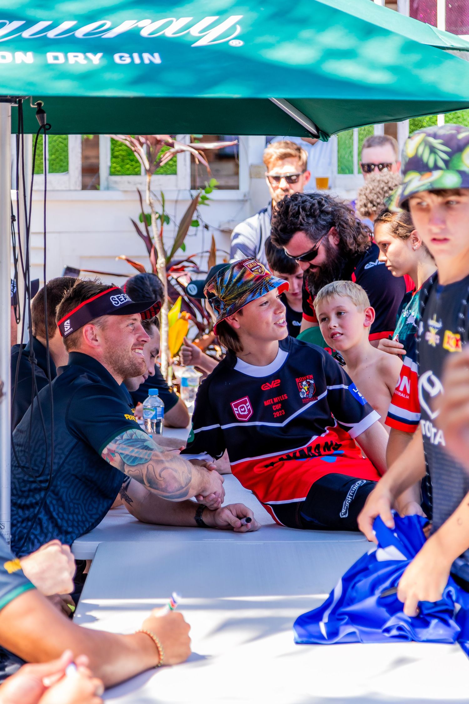 Sports fans gather under a branded tent for autographs at a community event.