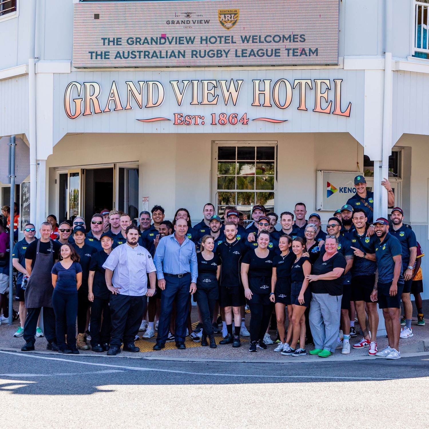 Large group photo outside the Grand View Hotel with sports team and staff.