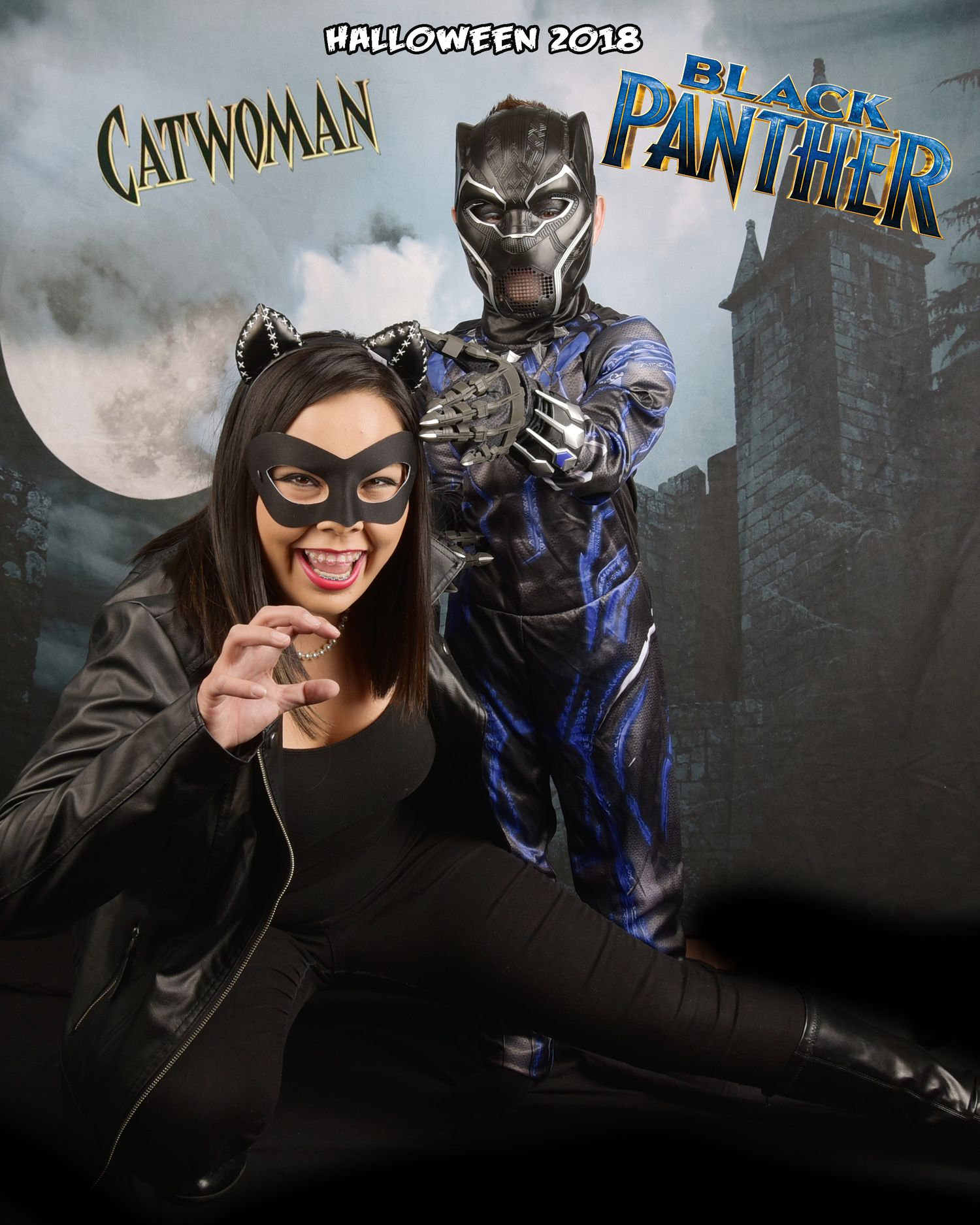 Superhero cosplay photo featuring Catwoman and Black Panther costumes against urban backdrop.