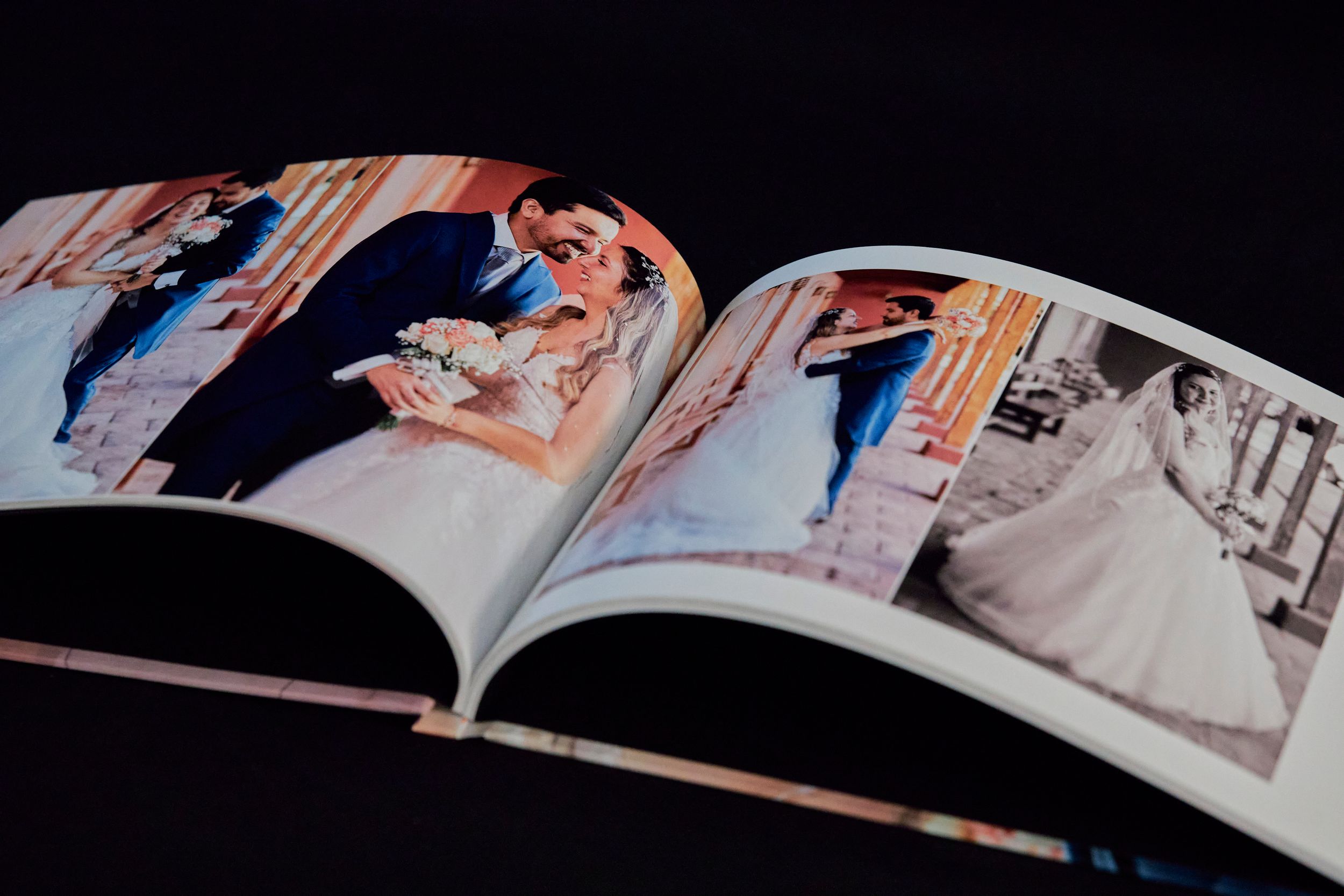 Open wedding album displaying professional ceremony photographs across two pages.