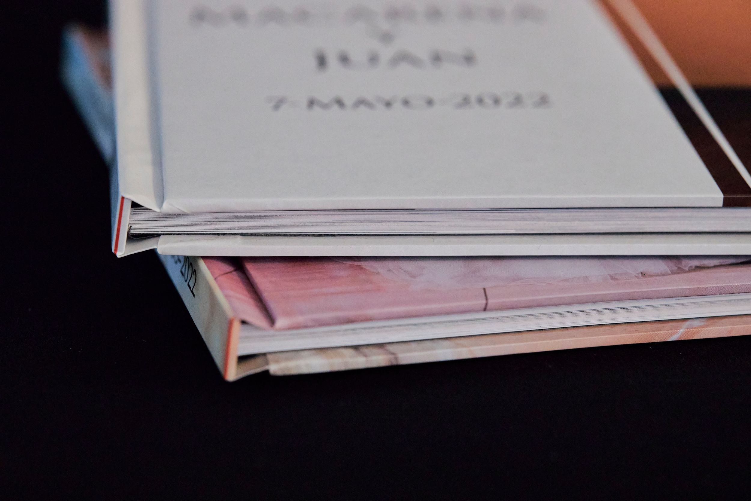 Stack of wedding photo books showing spine details and dates.