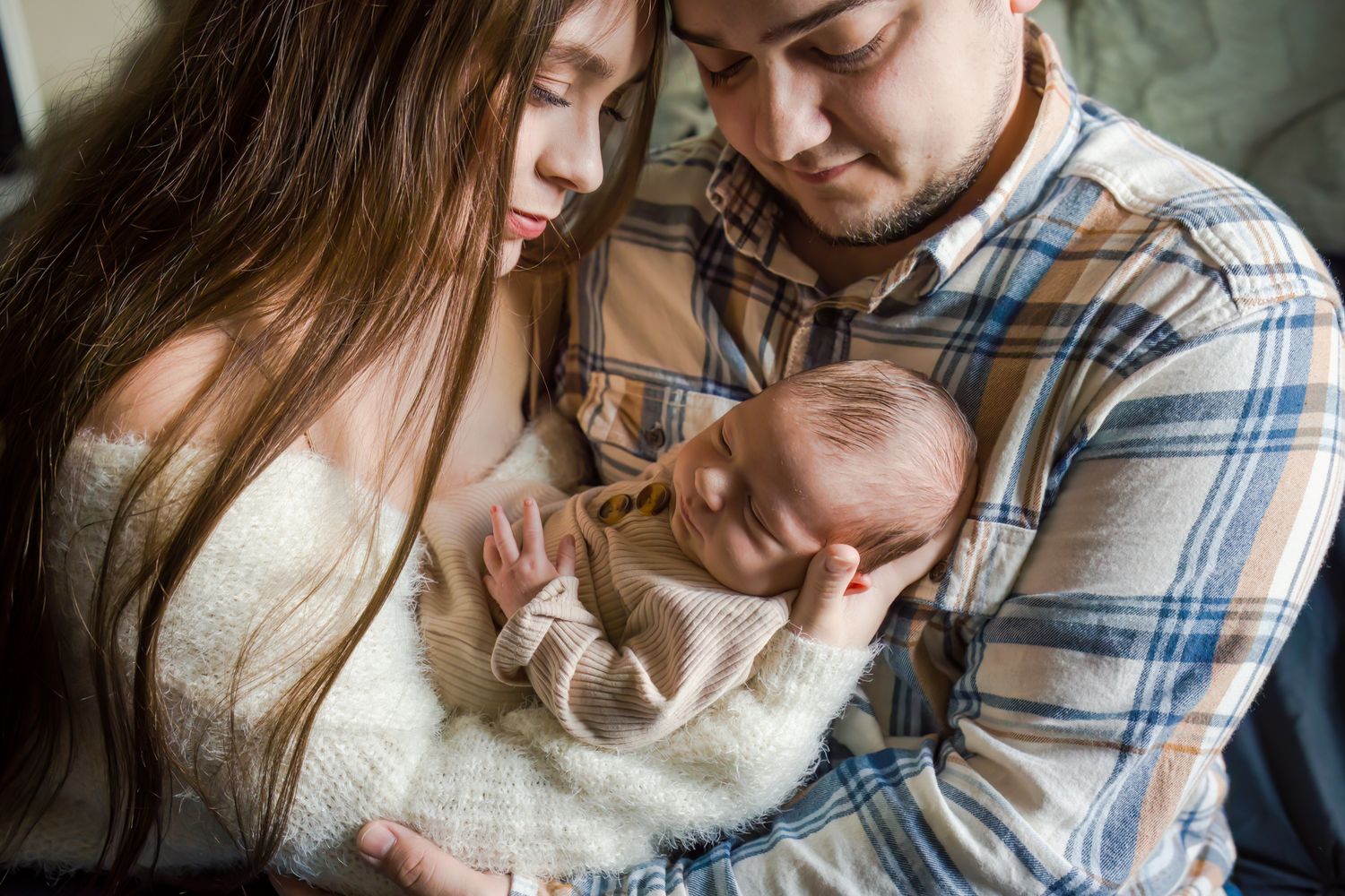 mom and dad holding newborn son