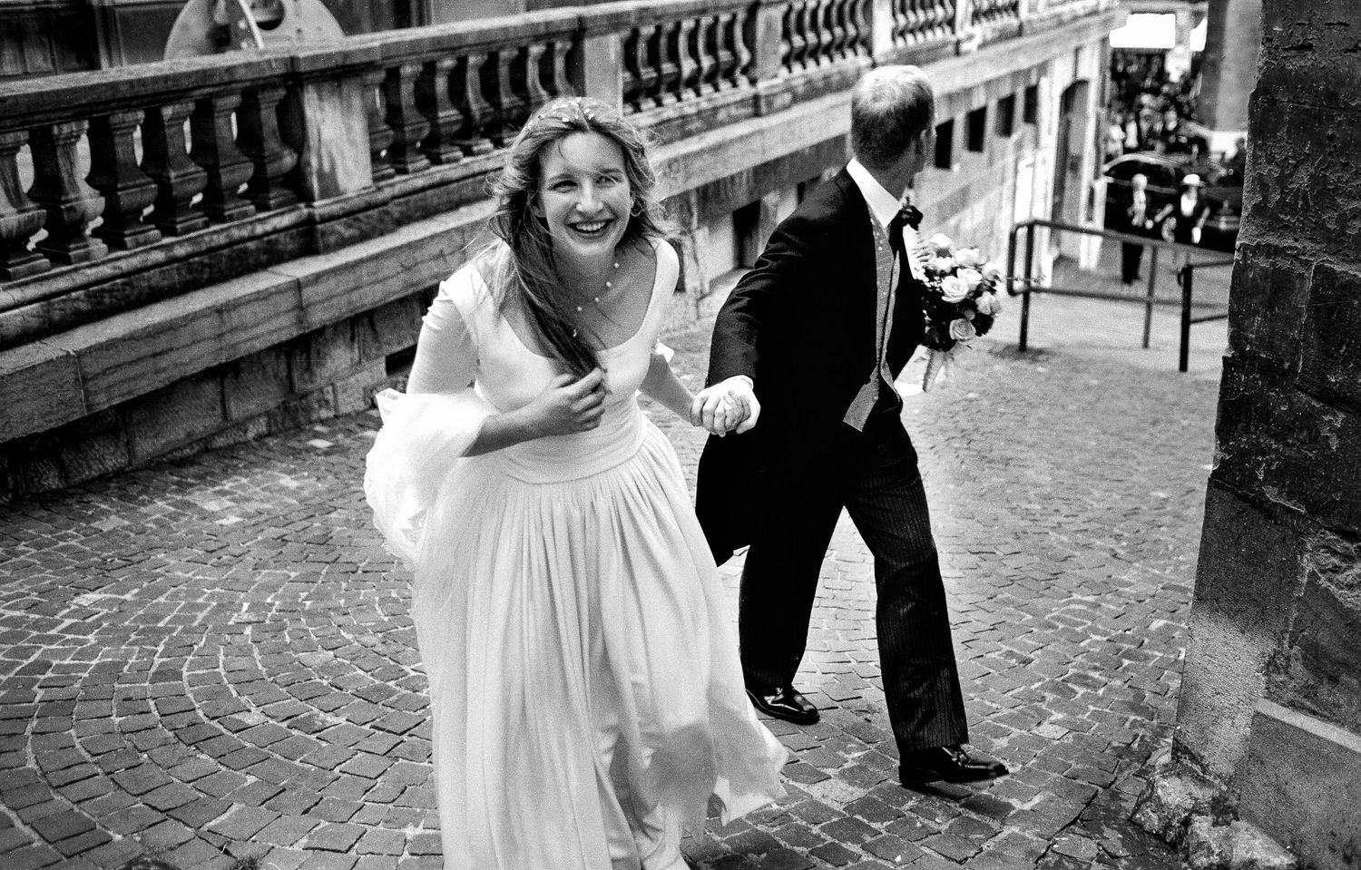 wedding analogue photography of bride leads groom up a hill in geneva