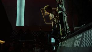 Silhouette of performer against turquoise lighting on stage.
