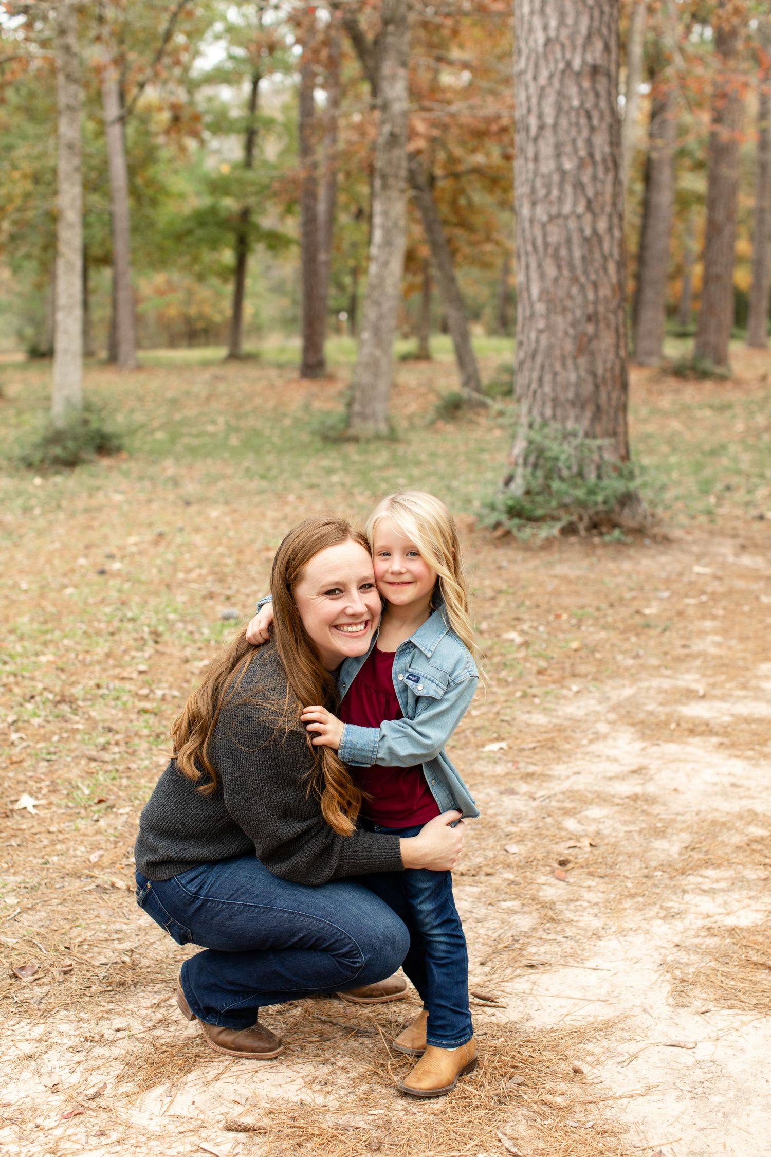 A heartwarming moment between parent and child on a wooded trail in autumn.