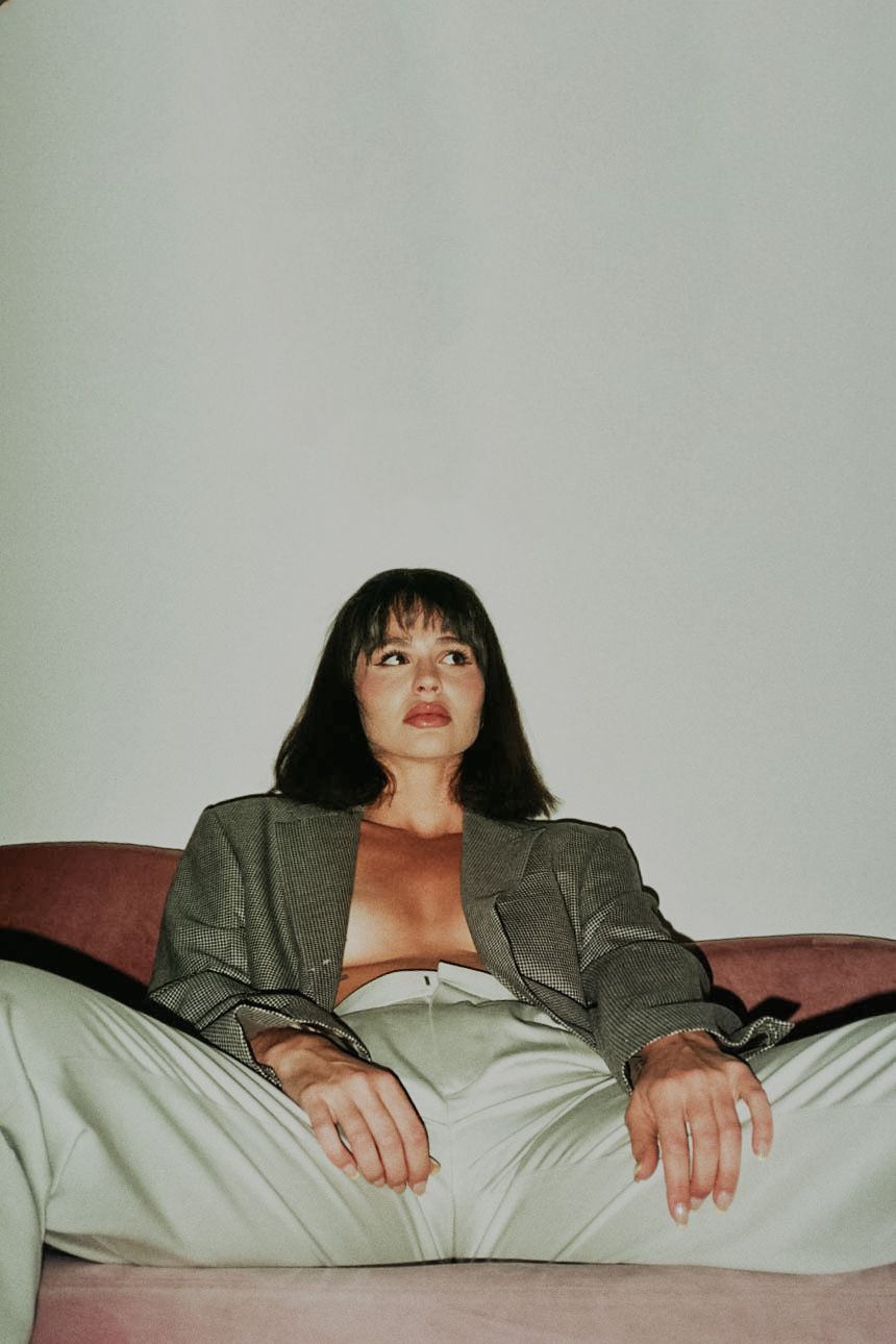 35mm film fashion portrait of woman in her home dressed in open blazer and slacks
