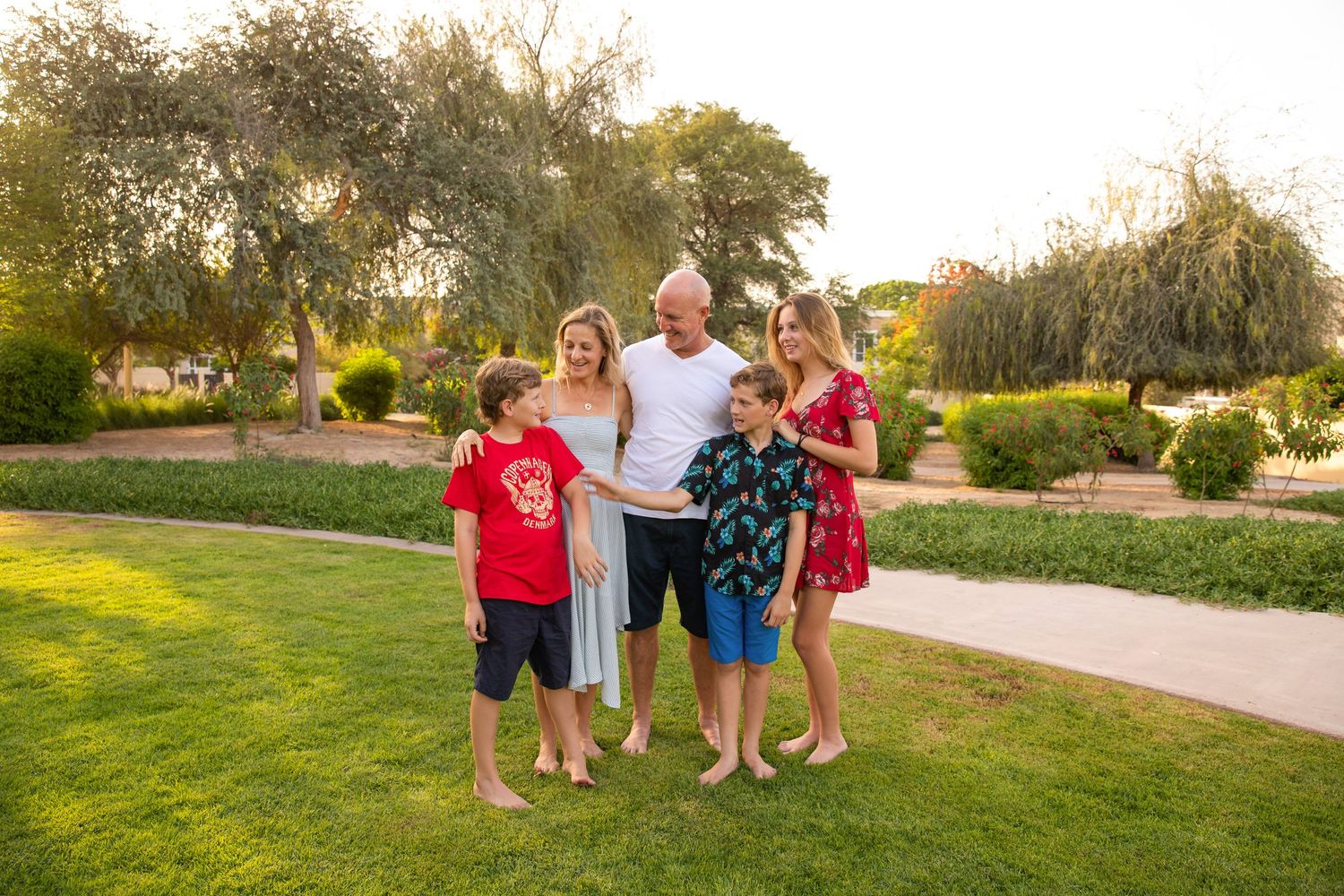 Family photoshoot in park with red clothes and green backdrop
