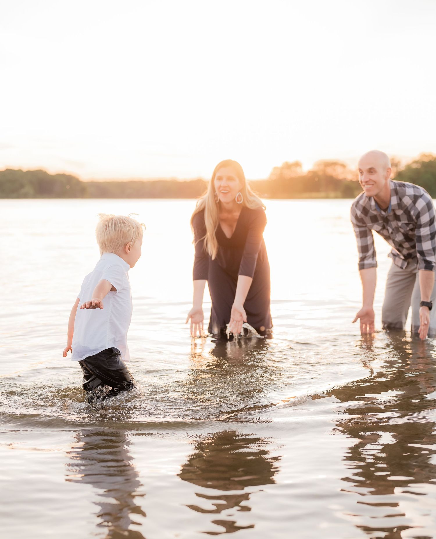 Family splashing in the water and laughing in Staten Island, NY