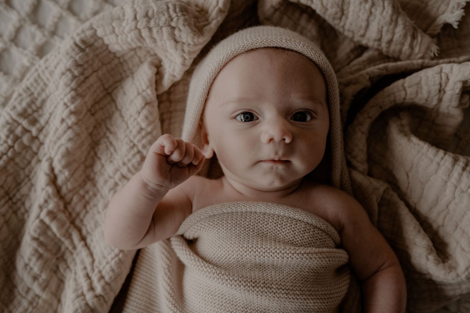 Intieme newborn foto van een pasgeboren baby, zacht verlicht en vol liefde.