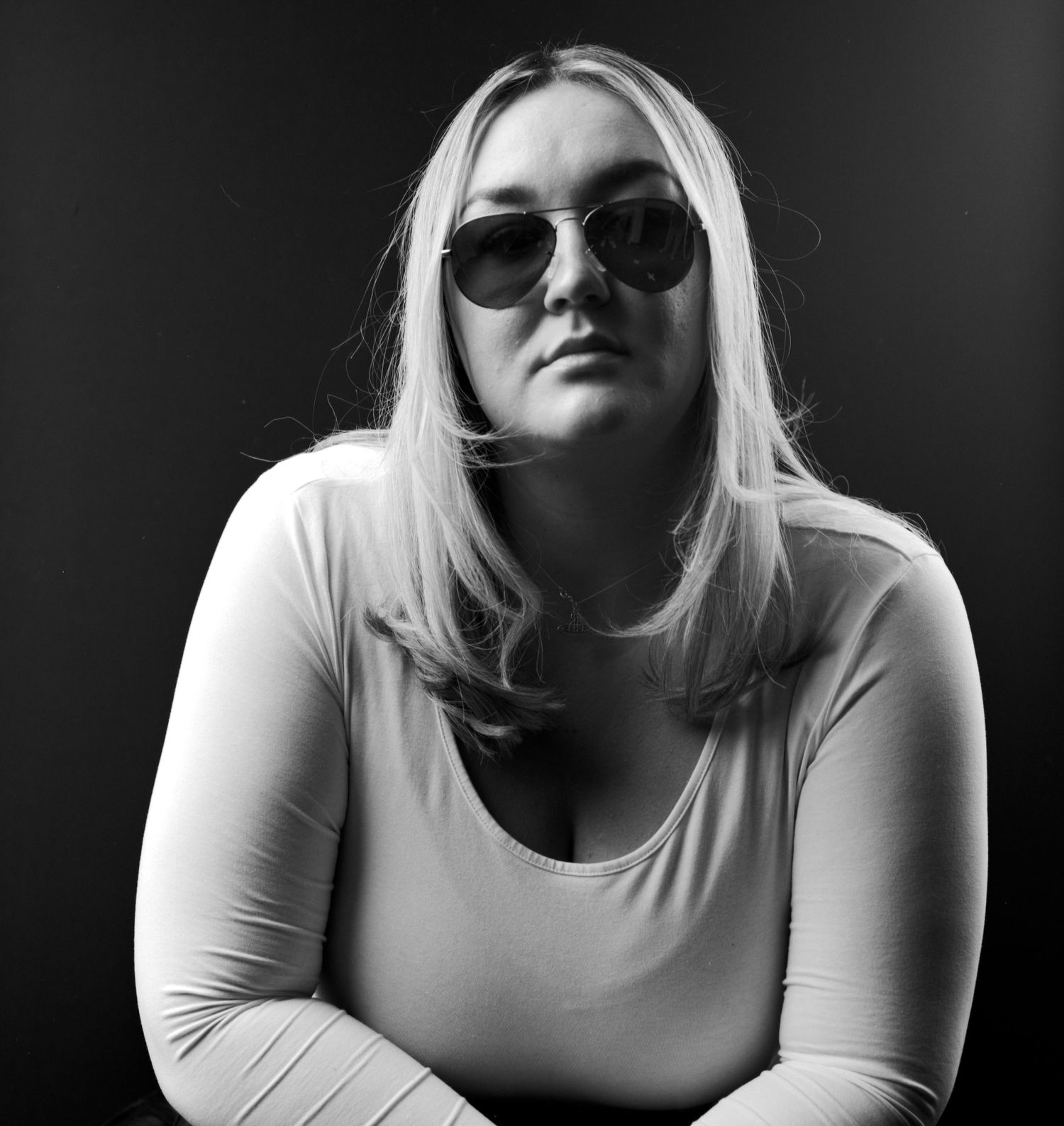 Black and white head and shoulders portrait photograph of young lady captured in the studio