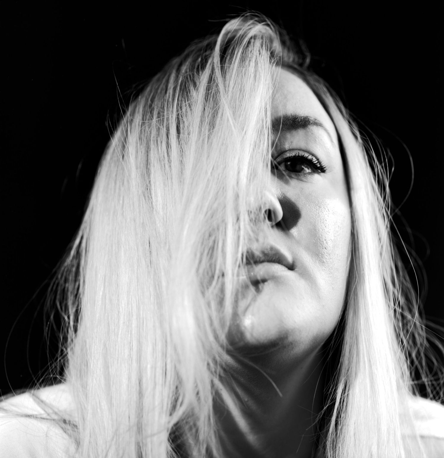 Black and white head and shoulders fresnel portrait photograph of young lady captured in the studio