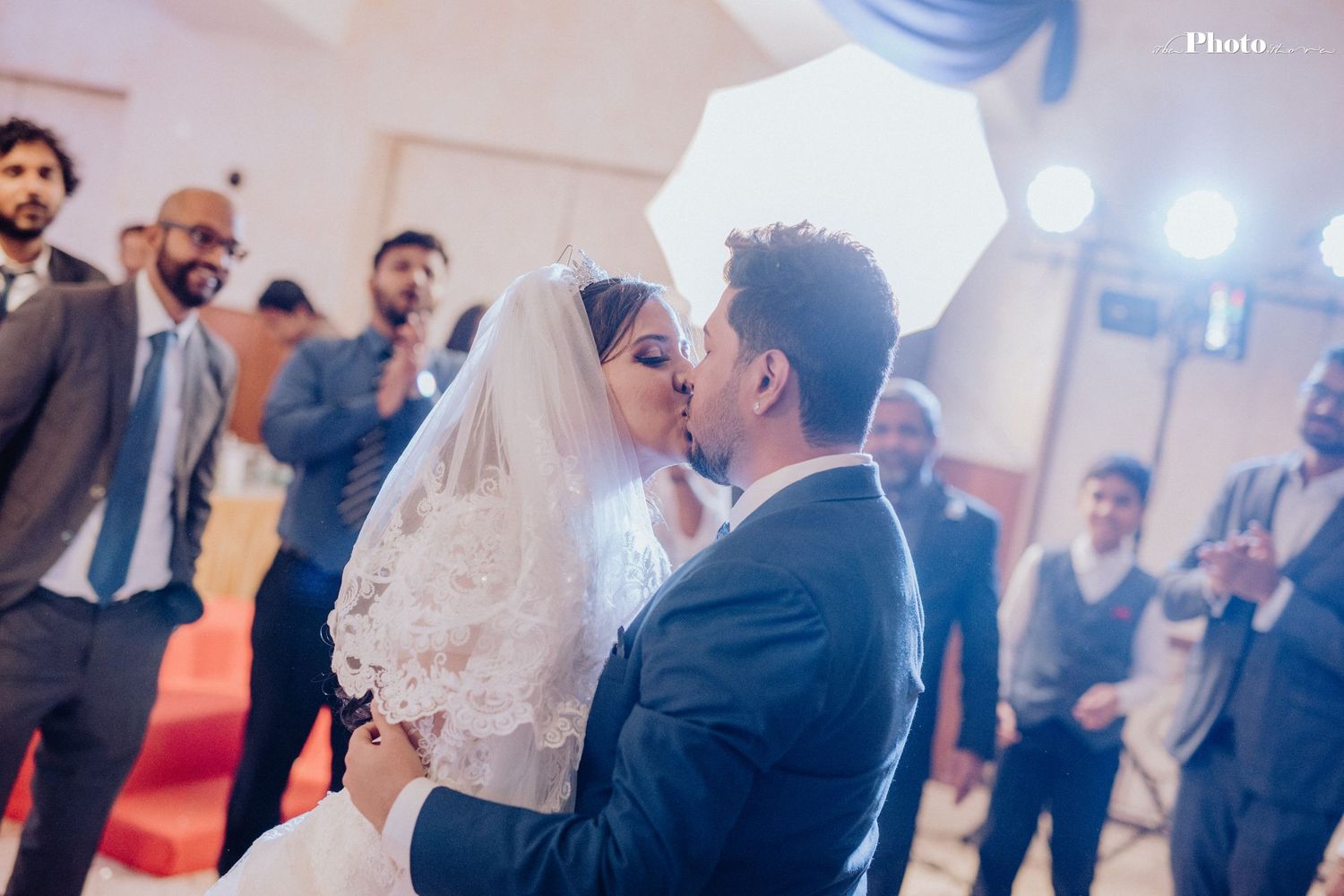 Romantic wedding moment with bride in white veil during reception celebration.