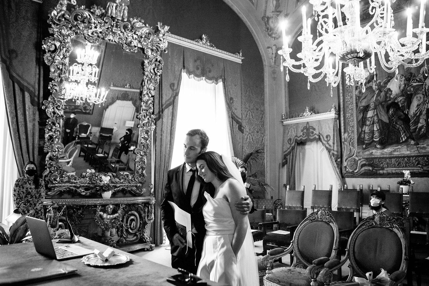 bride and groom in an emotional moment watching the screen of a MacBook as the bride's father does a speech